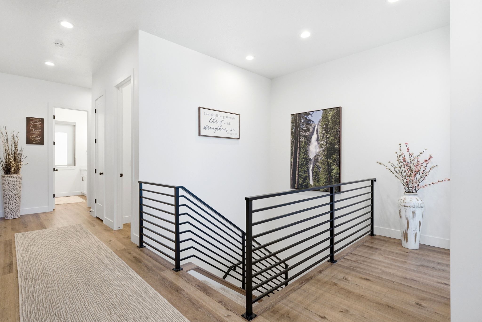 Upper-level landing featuring modern horizontal metal railings and recessed lighting