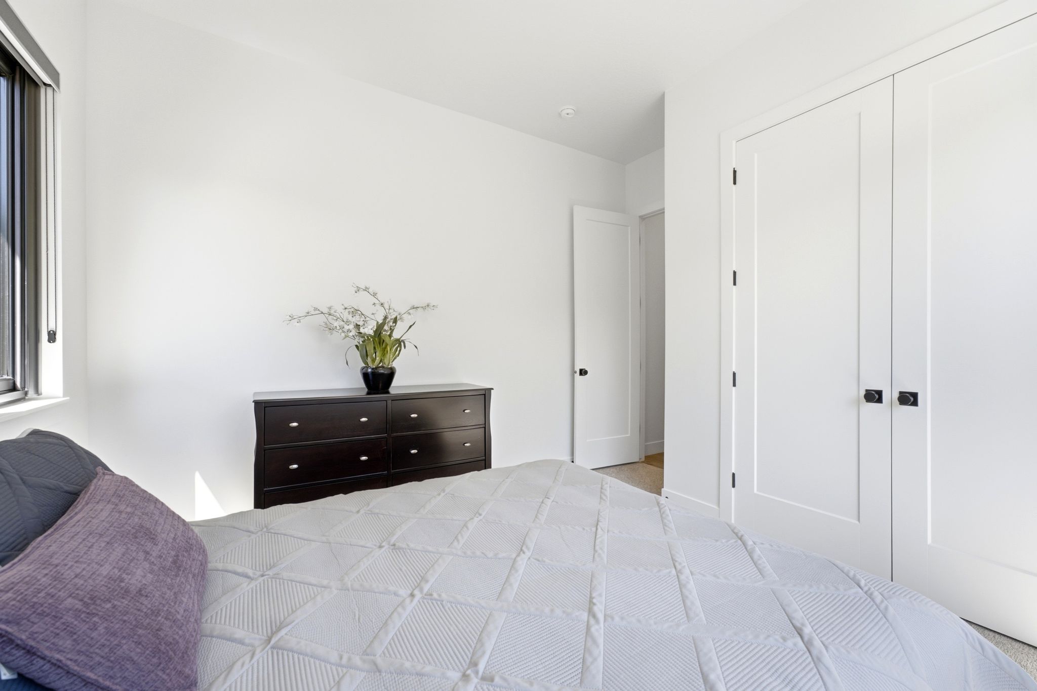 Bedroom featuring a large window with dark trim, recessed lighting, and light-toned flooring