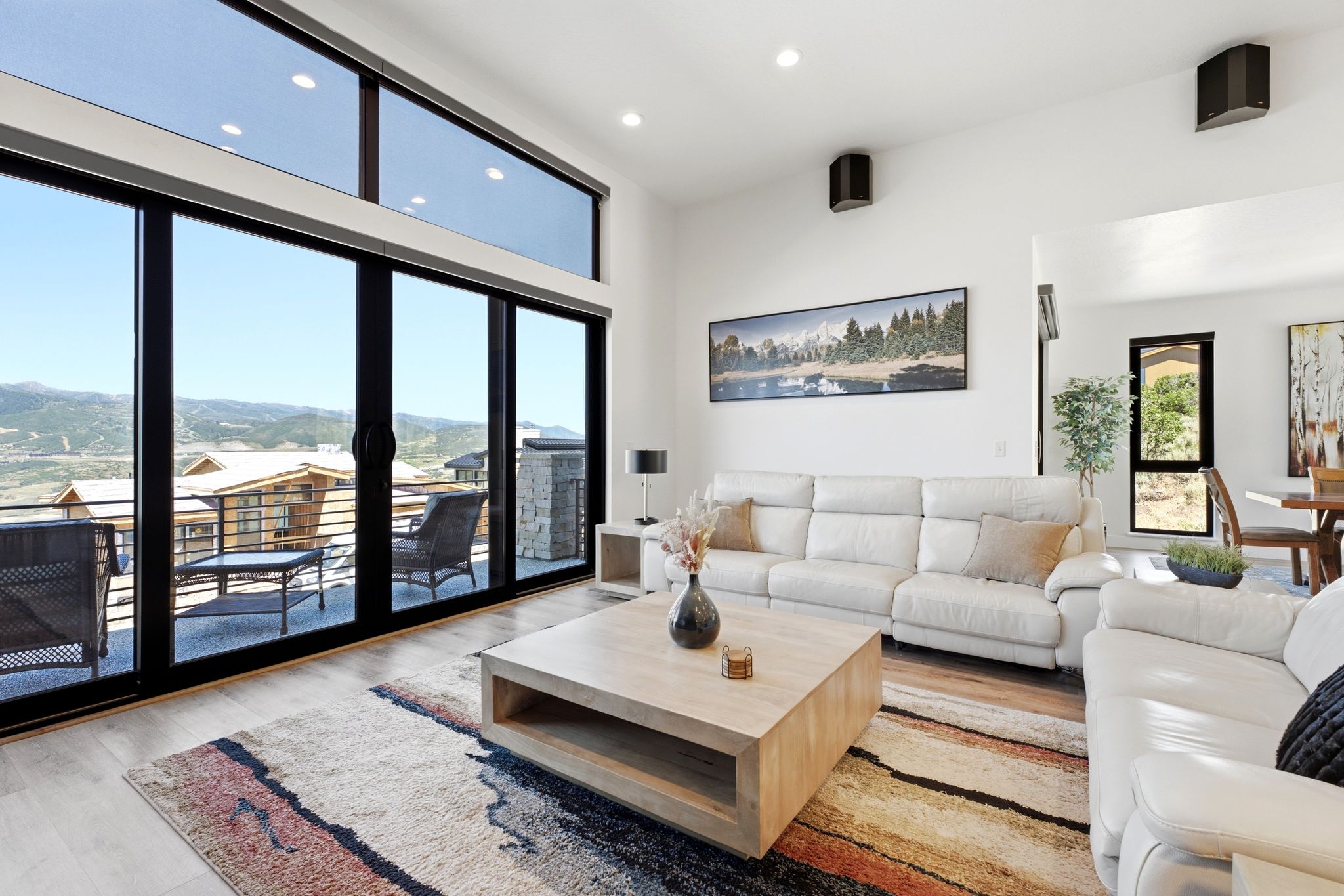 Spacious living area featuring expansive floor-to-ceiling sliding glass doors, upper transom windows, and recessed lighting