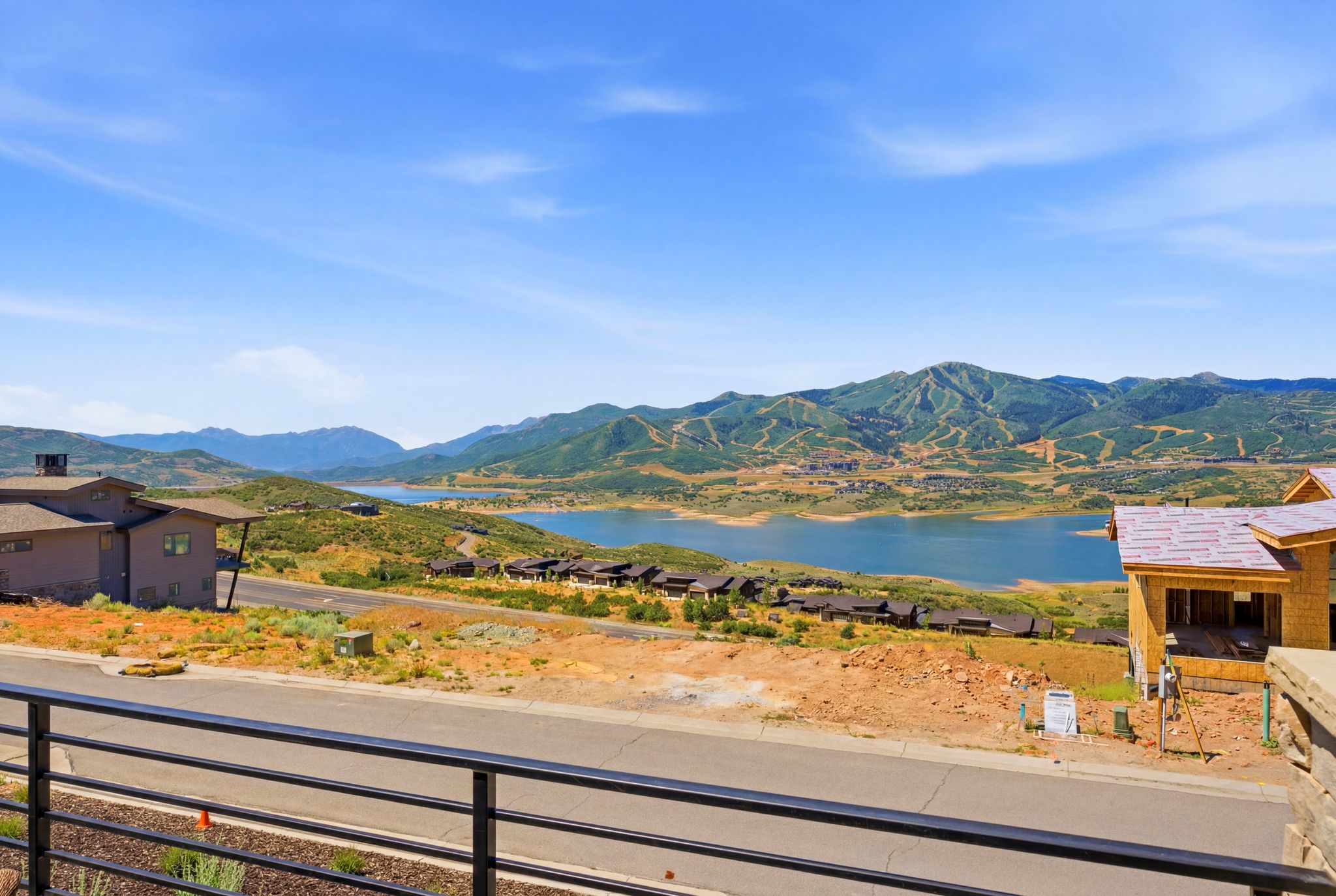 Expansive mountain and lake scenery with a contemporary metal railing