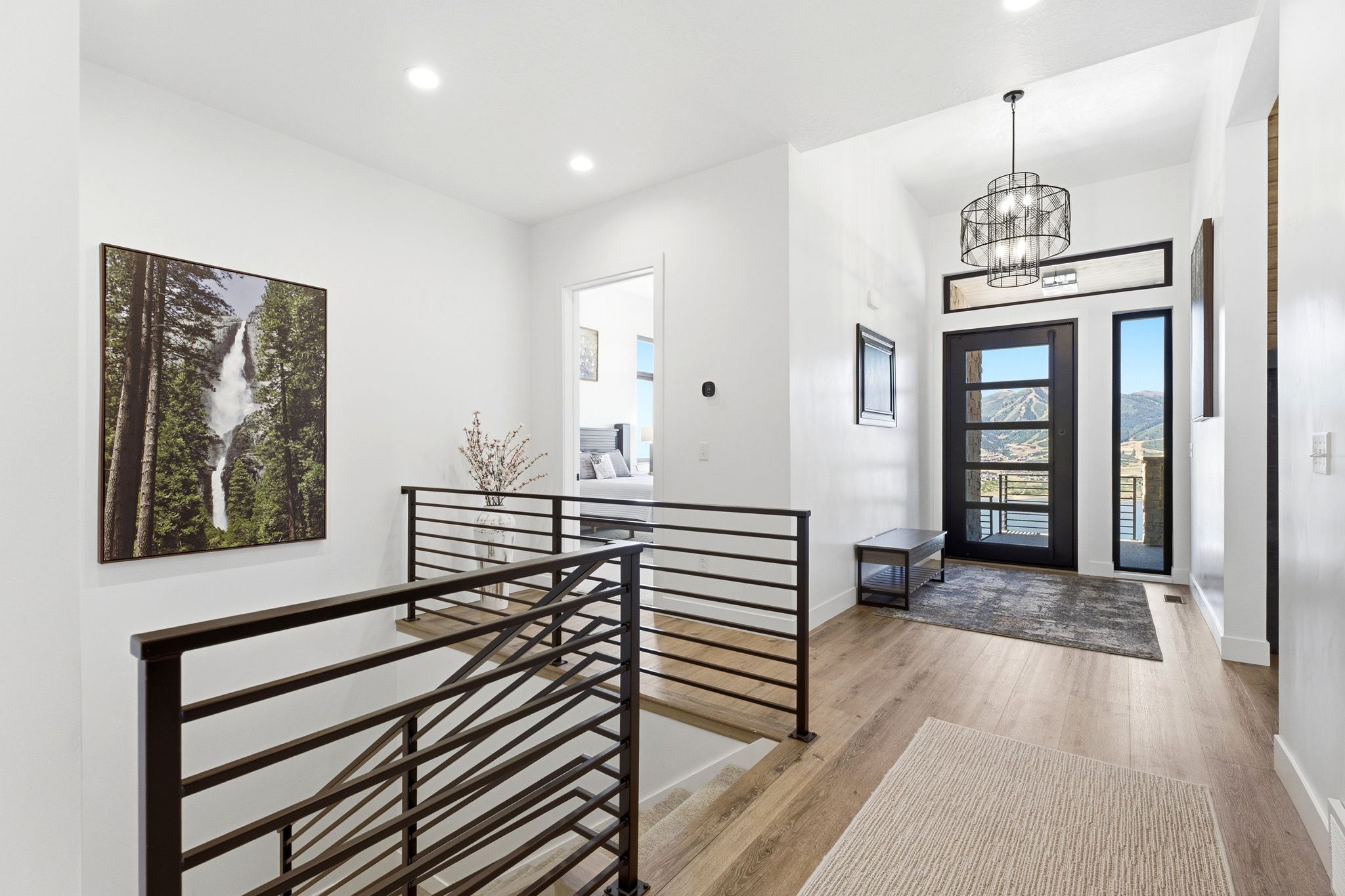 Entryway featuring a contemporary glass-paneled door, surrounding sidelight windows, and a modern chandelier