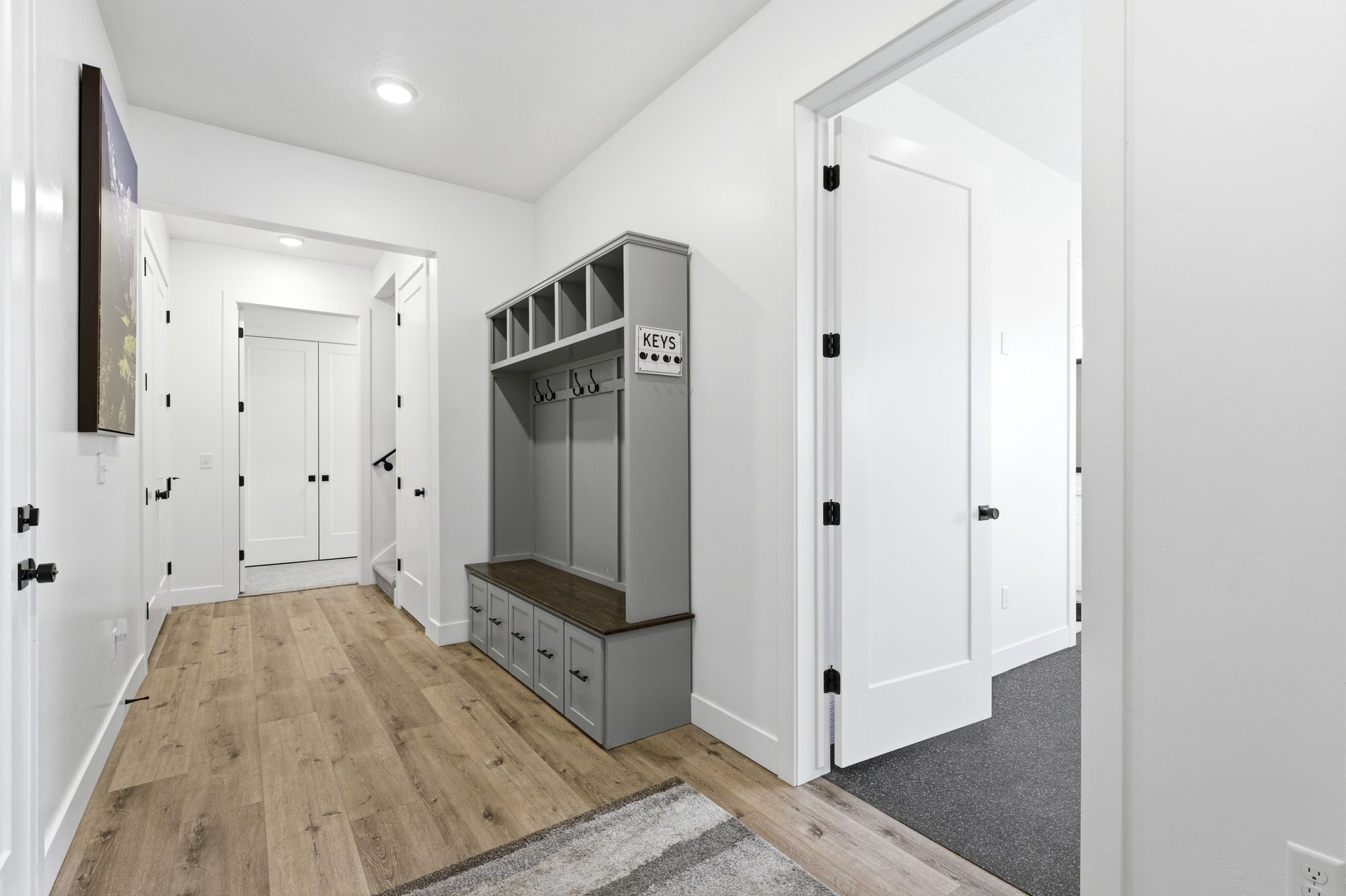 Entryway featuring wood-finish flooring, a built-in bench with storage, and white walls