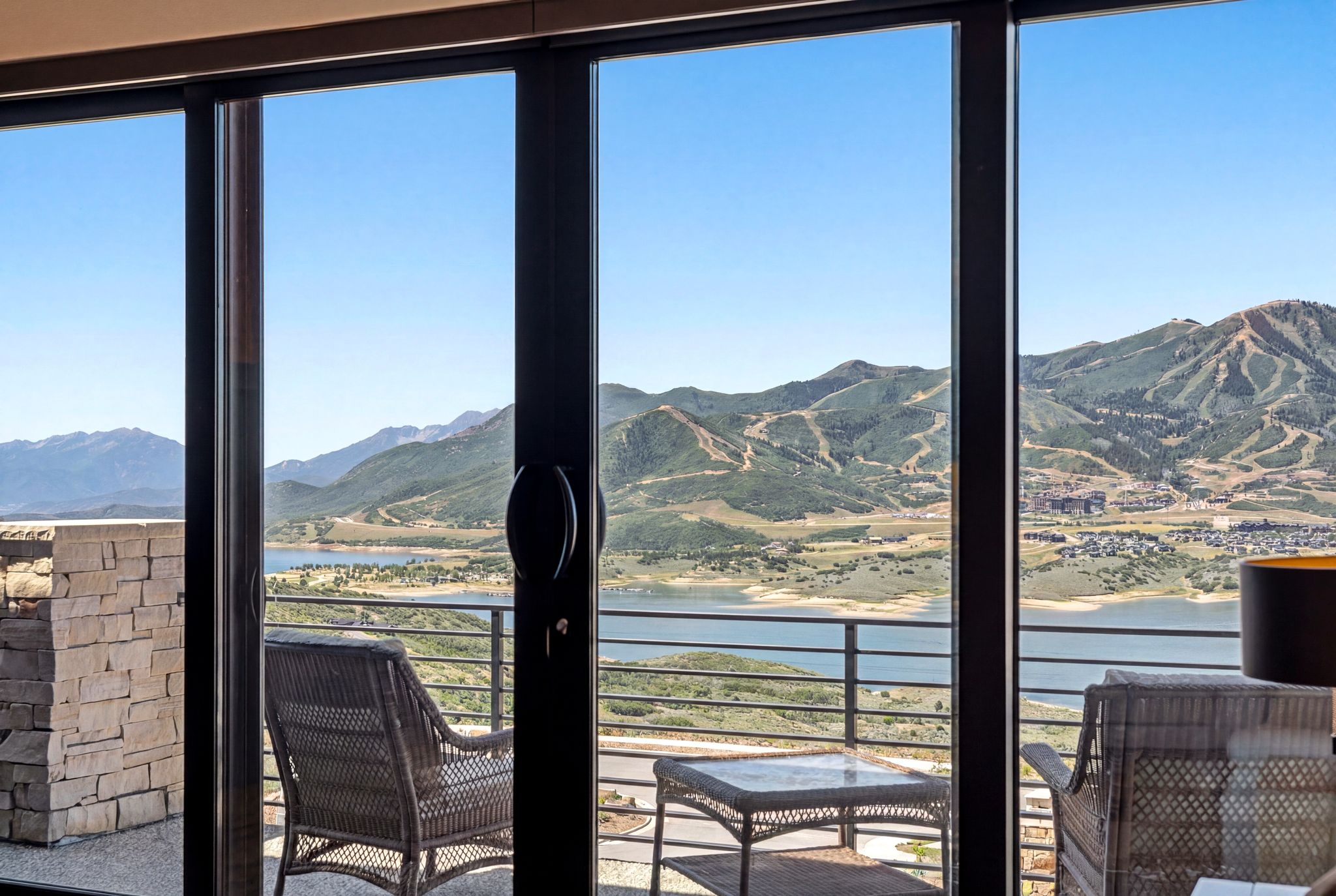 Expansive sliding glass doors open to a stone-clad exterior patio