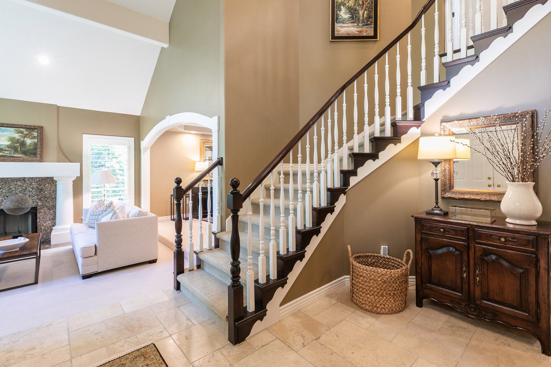 Grand staircase with dark wood-finish handrails and white balusters