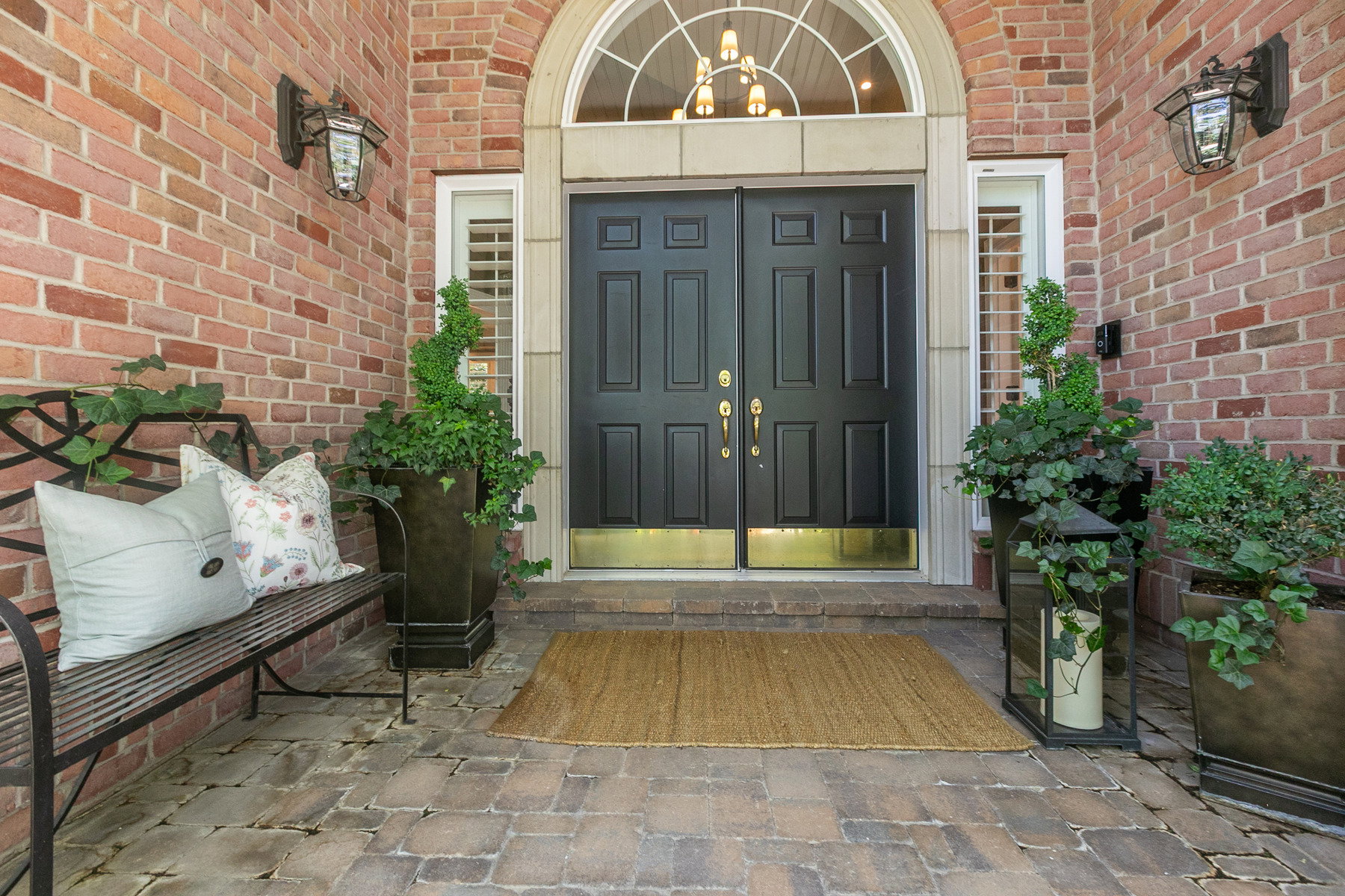 Brick exterior with a double entry door featuring gold kickplates and hardware