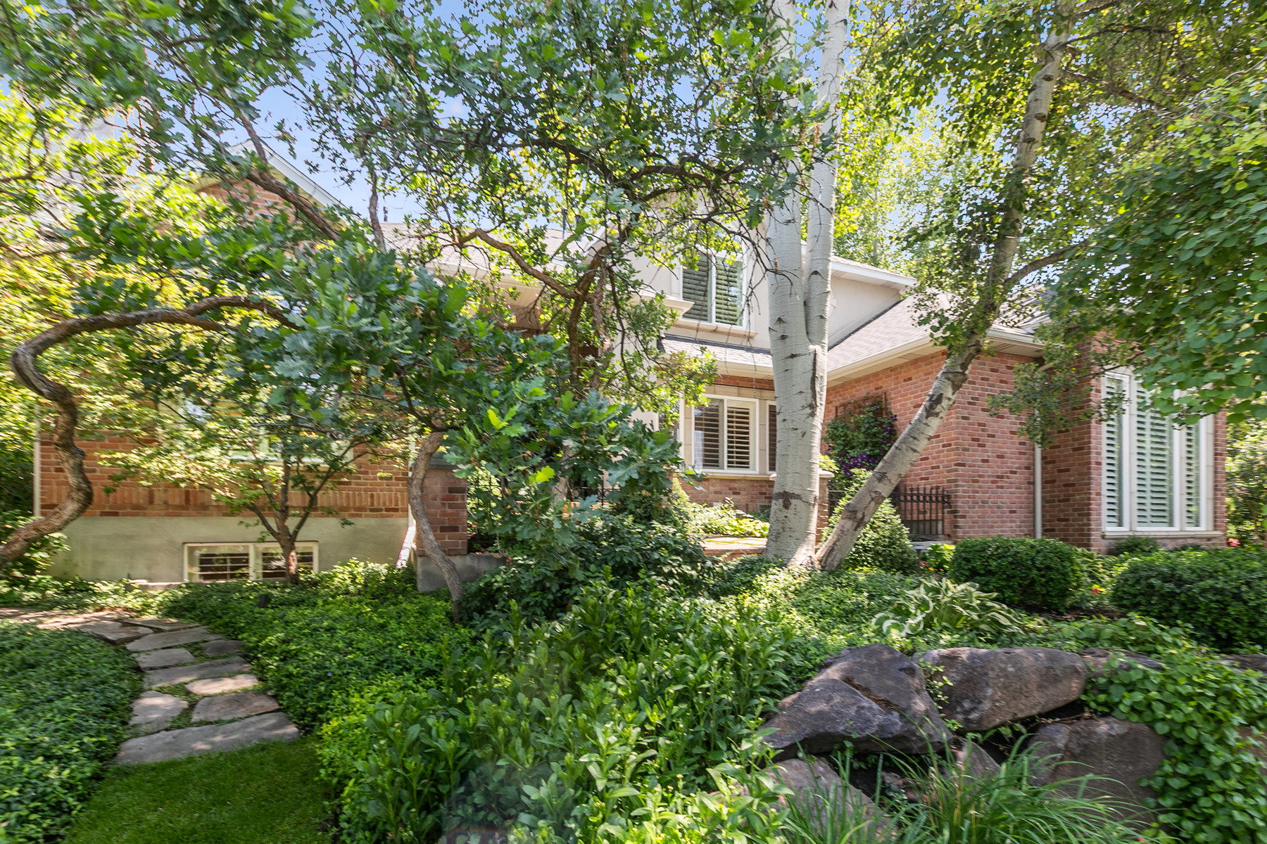 Brick exterior residence featuring multiple windows with louvered shutters