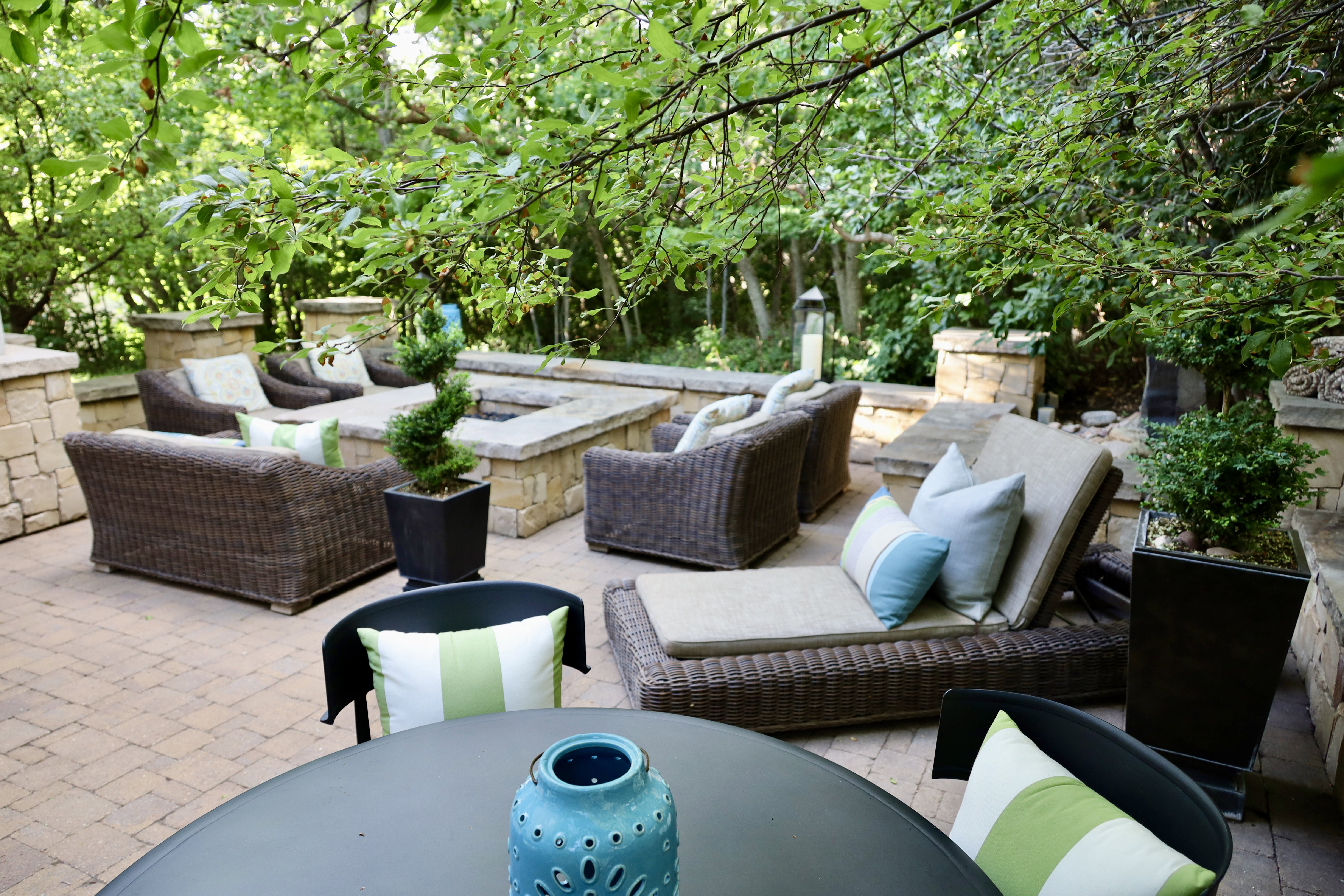 Spacious paver patio with a built-in stone fire pit, surrounded by stone retaining walls