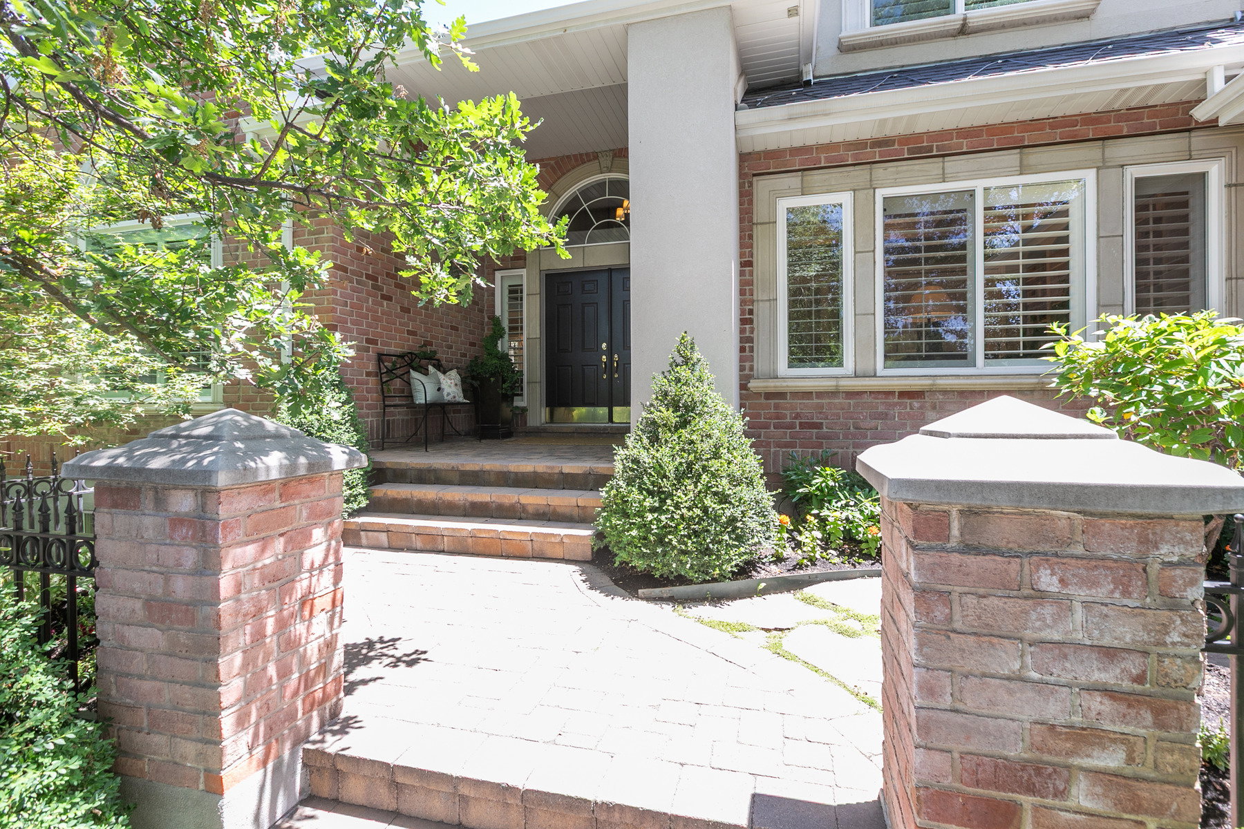 Brick exterior featuring a portico entrance with a single column