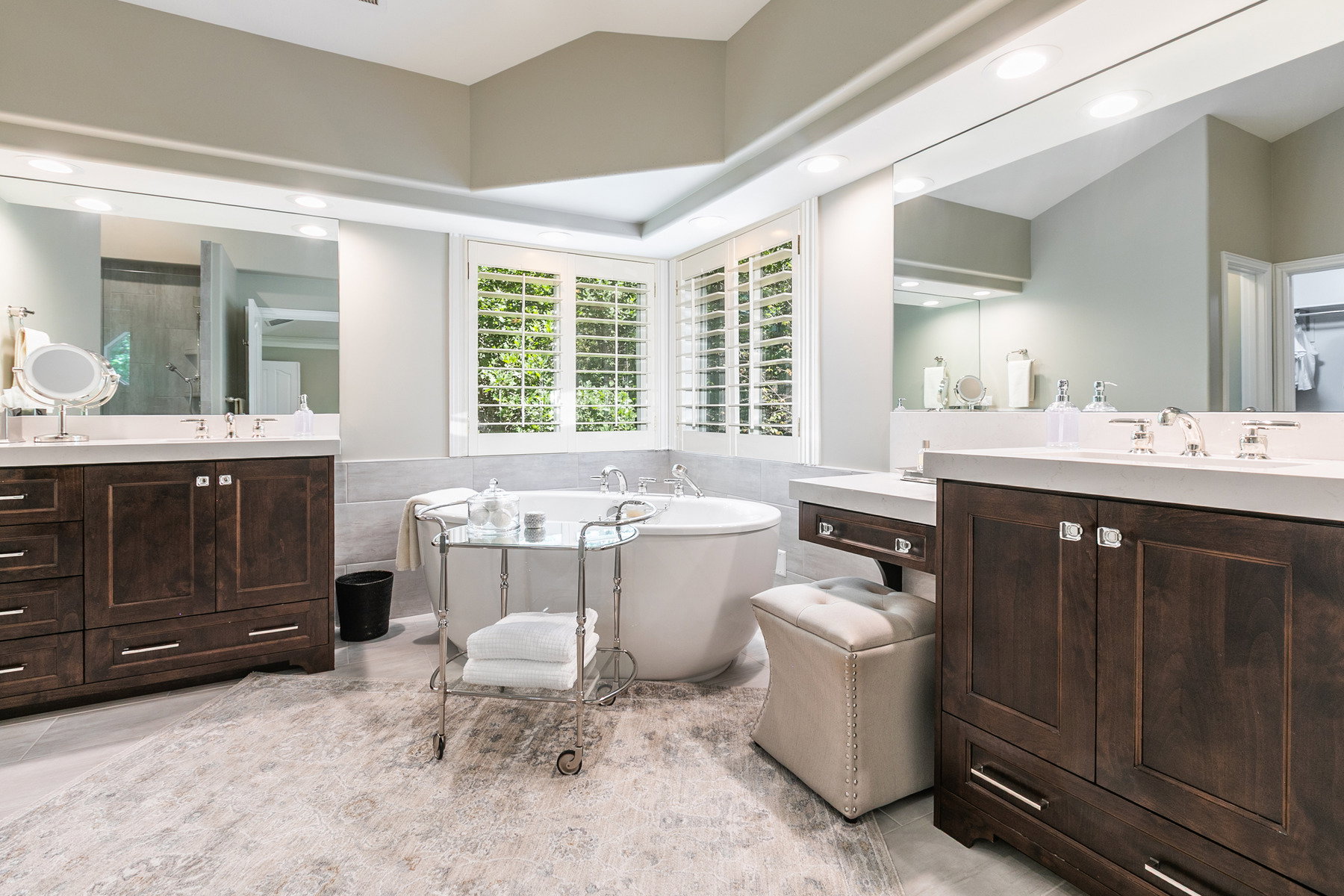 Freestanding soaking tub with plantation shutters in the primary bathroom