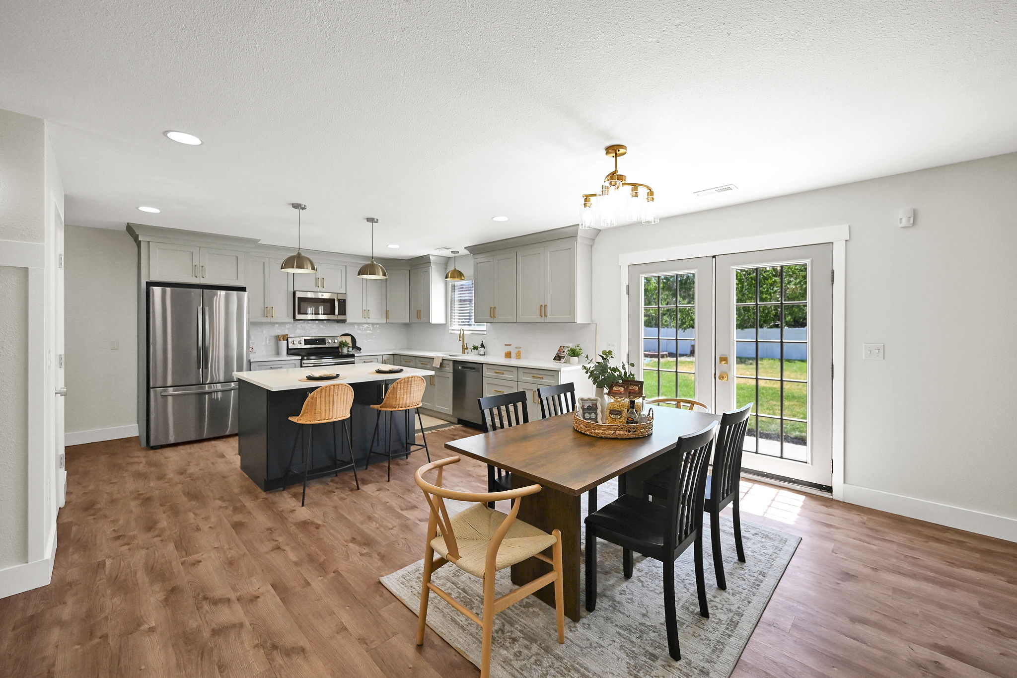 Open-concept kitchen and dining area featuring wood-finish flooring, recessed lighting, and a kitchen island with seating