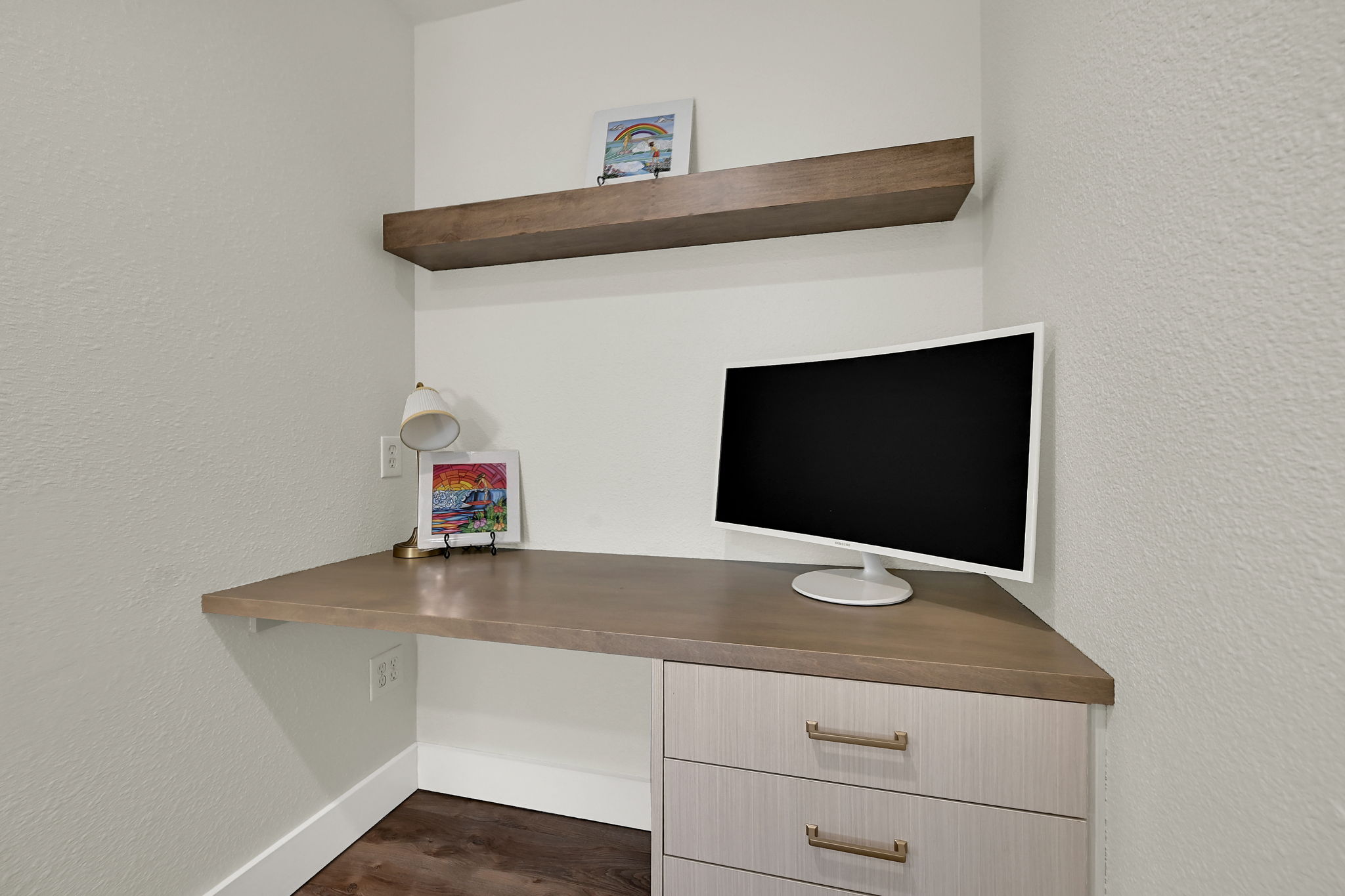 Built-in corner desk with a neutral-toned countertop and integrated cabinetry