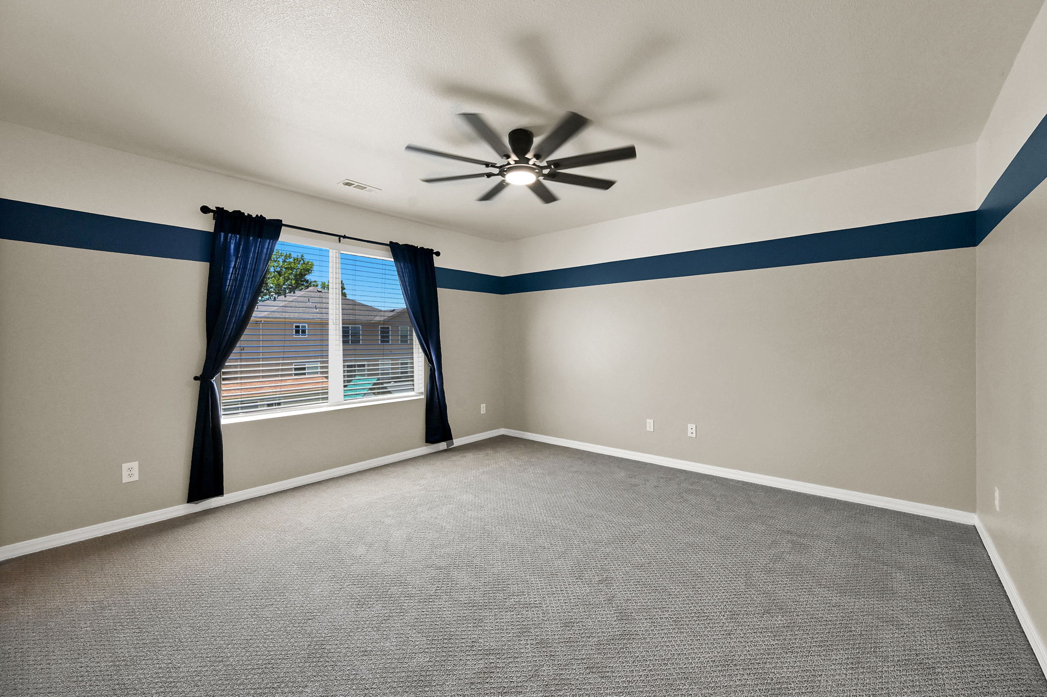 BEDROOM 5 Spacious room featuring neutral carpeting and a ceiling fan with integrated lighting