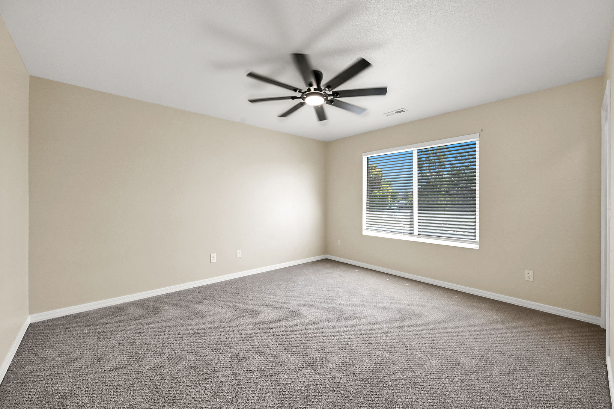 BEDROOM 4 Spacious room featuring neutral carpeting, light-toned walls, and a contemporary ceiling fan with integrated lighting