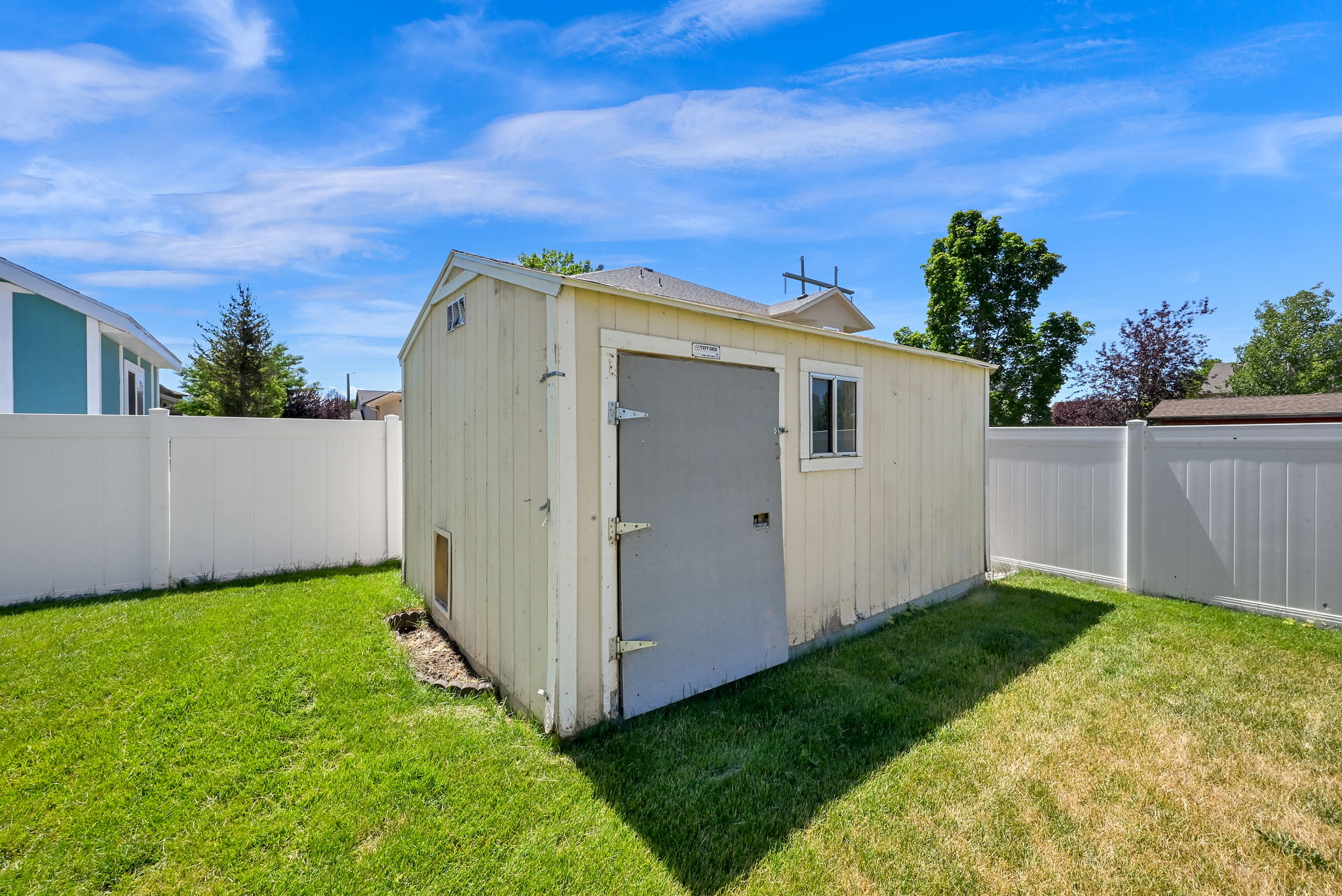 SHED Wood-sided utility shed featuring a single window and durable metal door