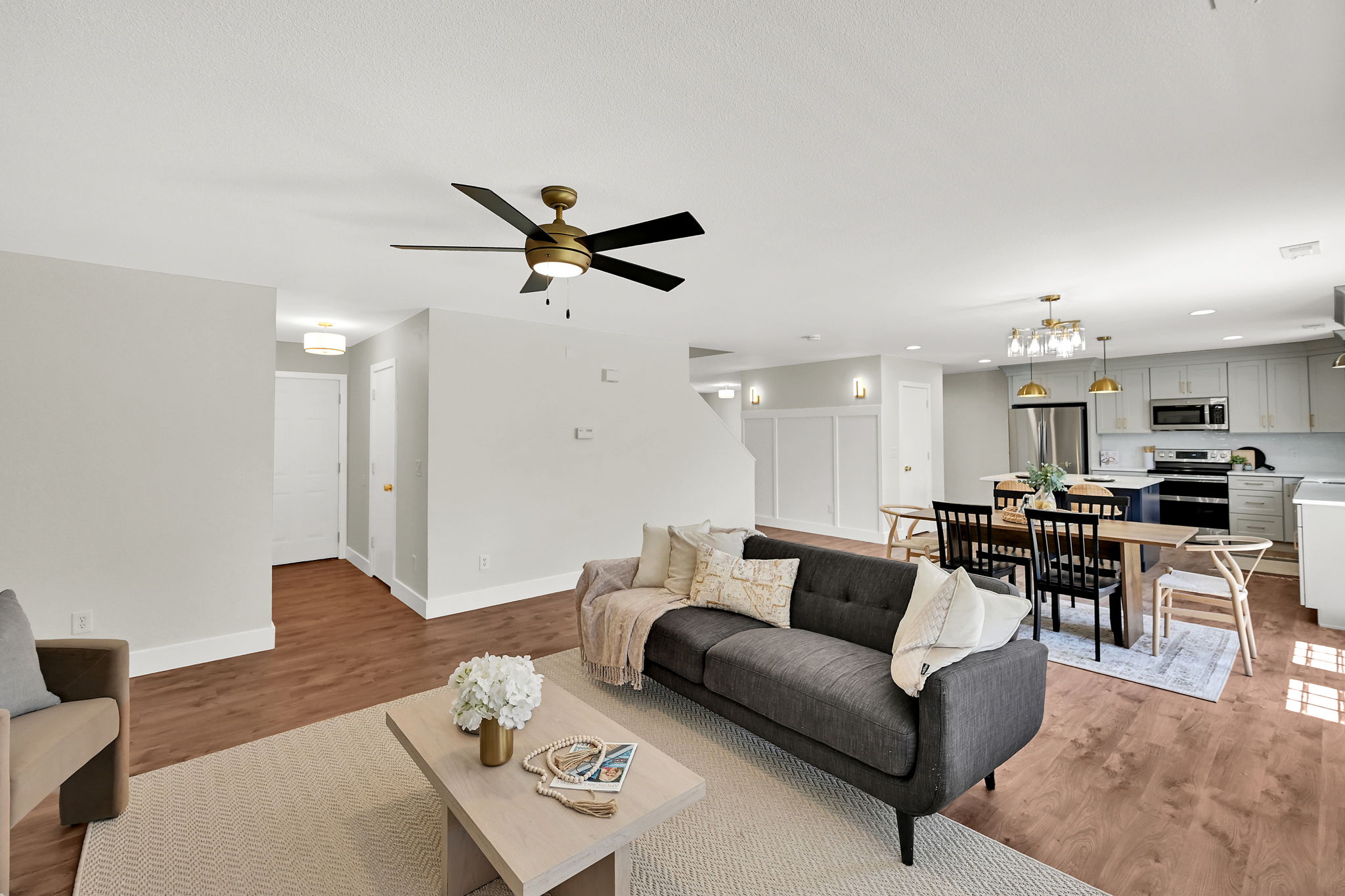 Open-concept living space featuring wood-finish flooring, a contemporary ceiling fan, and recessed lighting
