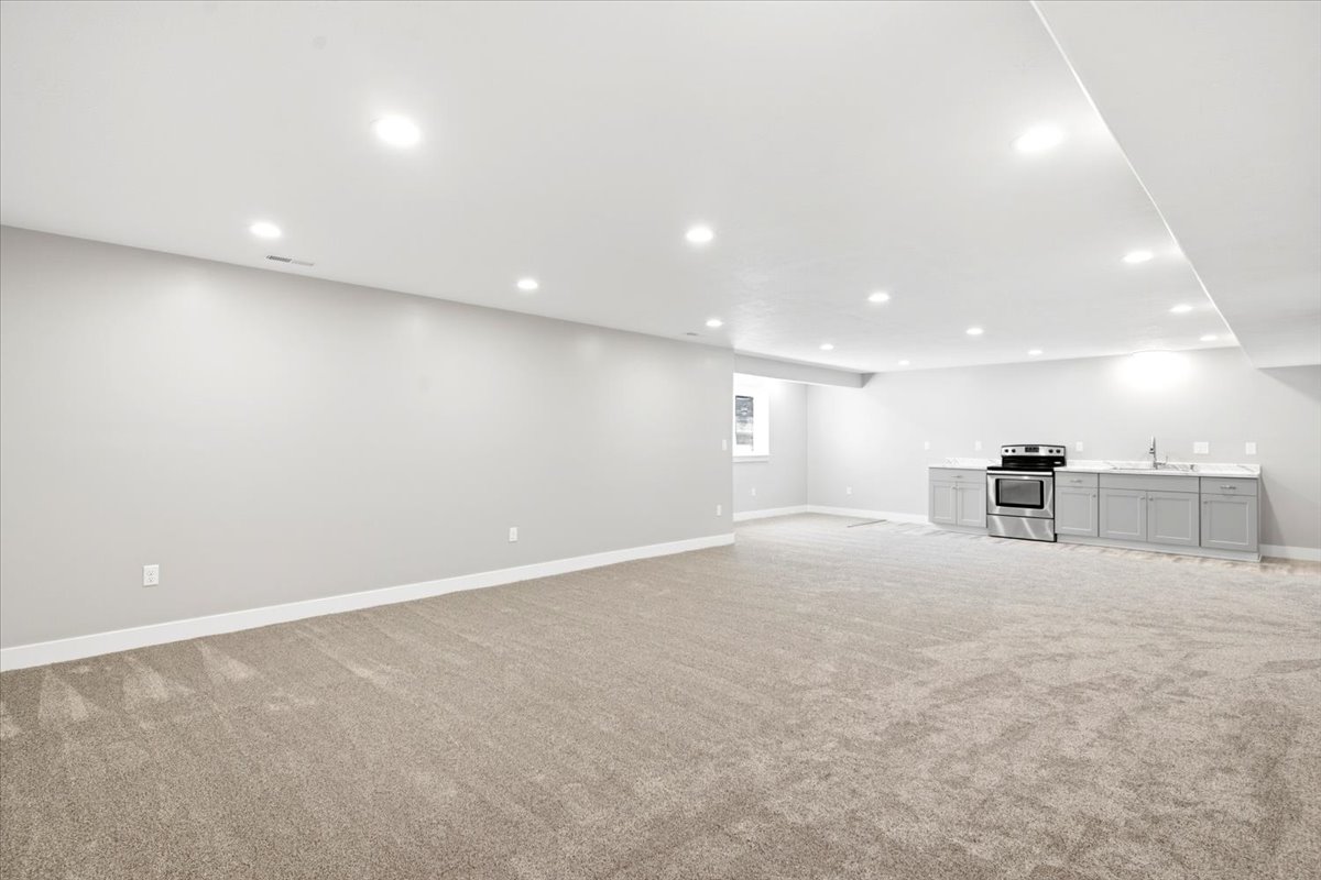Expansive open-concept room featuring neutral-toned carpeting and recessed lighting