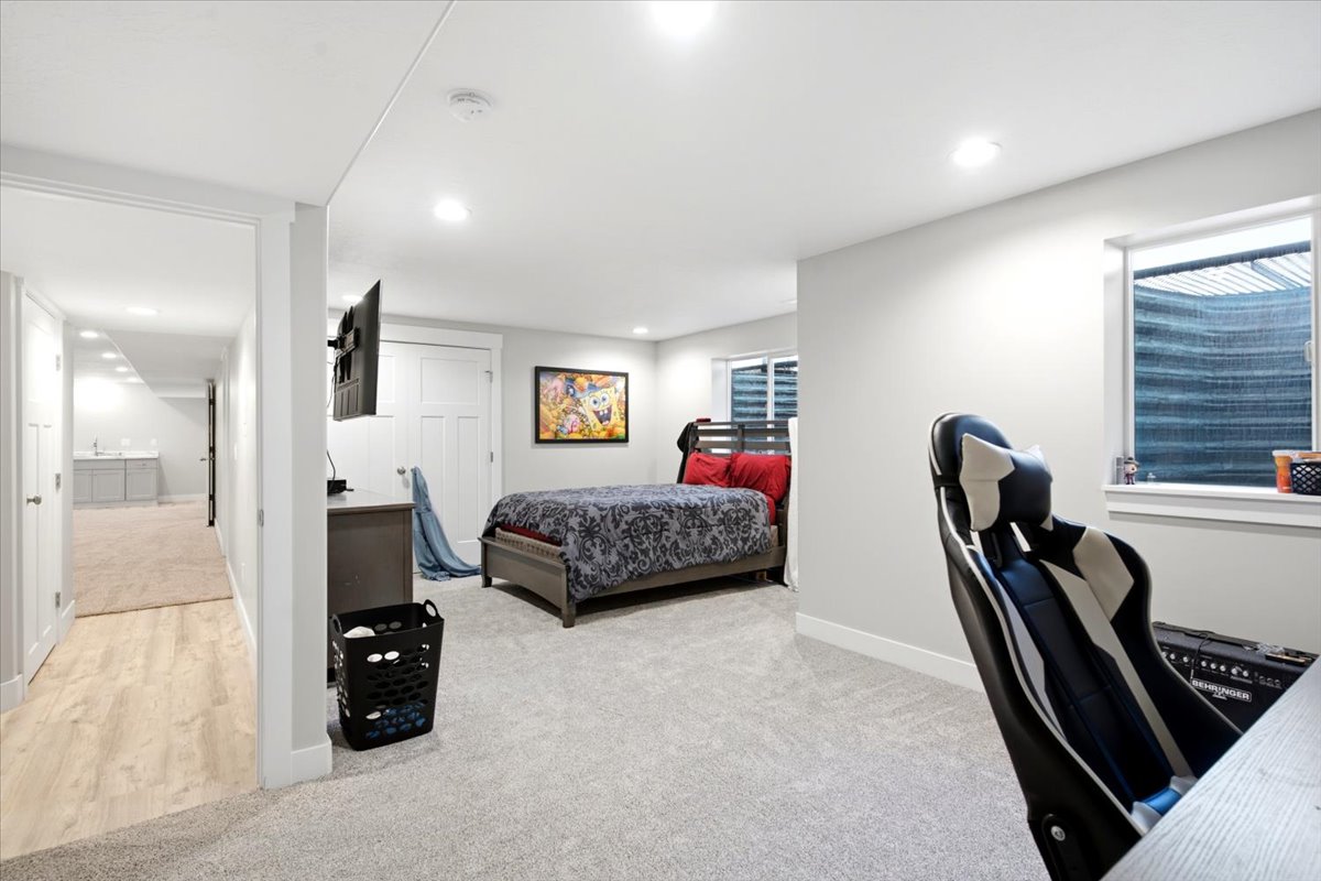 Spacious room with plush carpeting, recessed lighting, and a window with a privacy blind