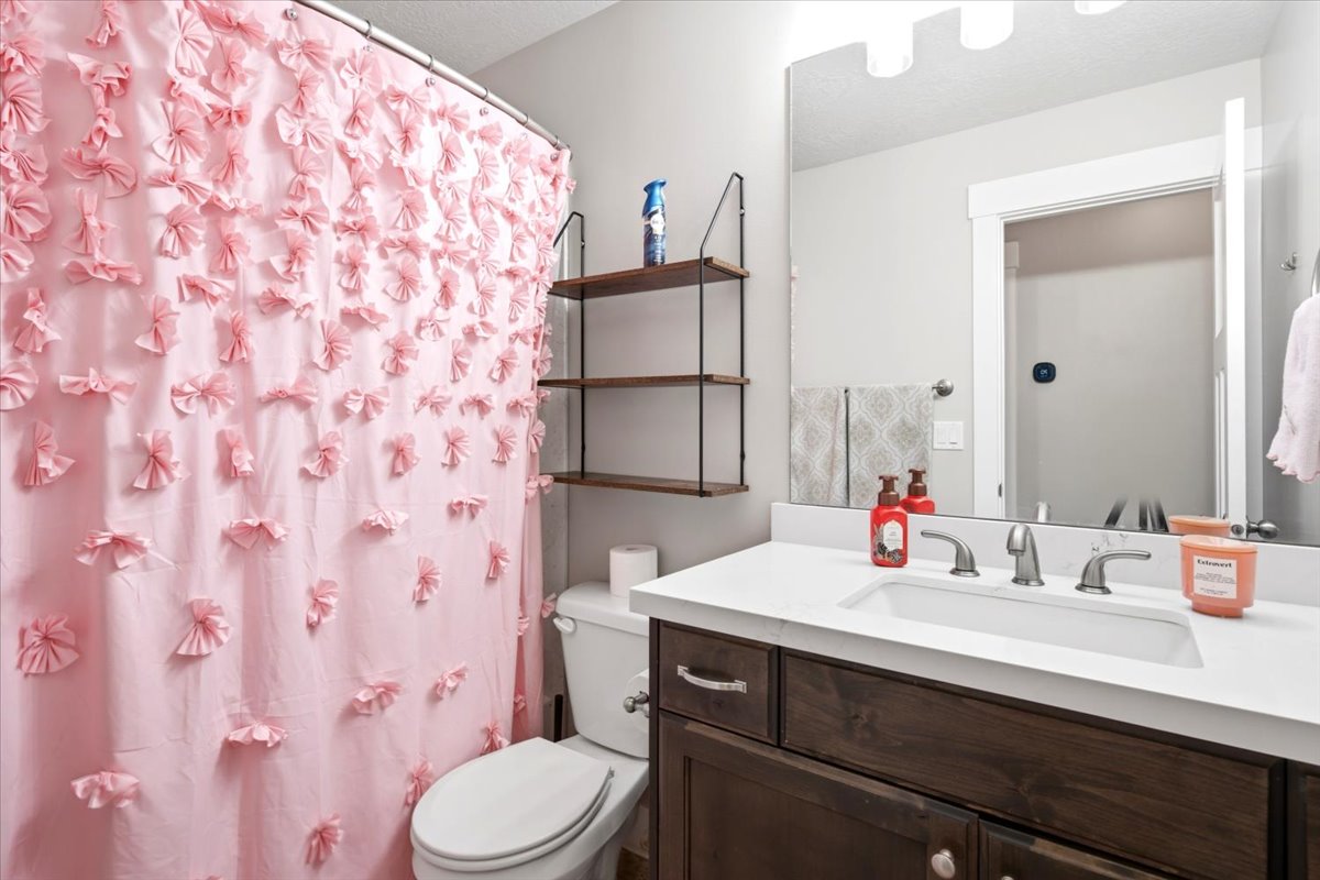 Bathroom featuring a dark wood-finish vanity, white countertop, and rectangular undermount sink