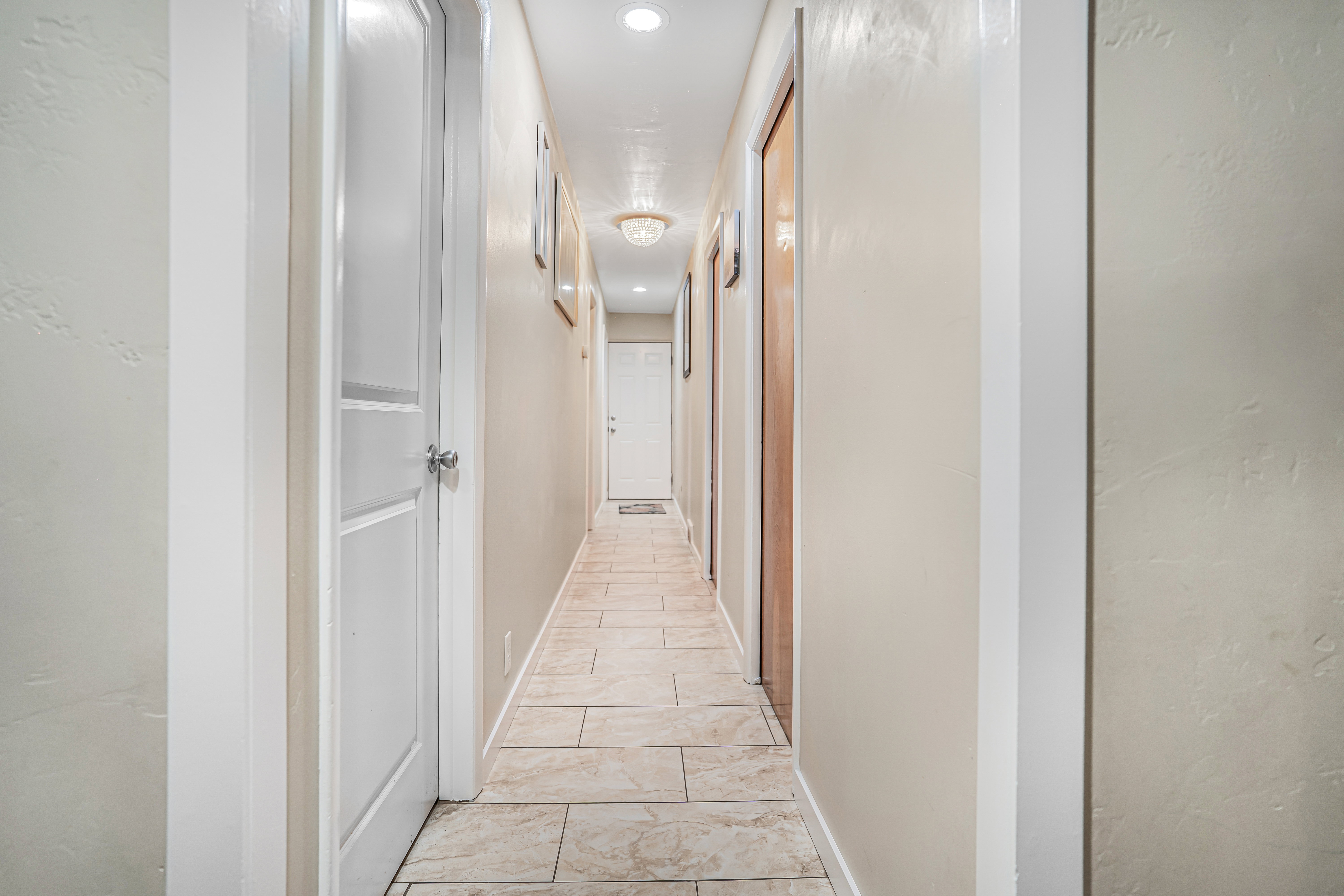 Hallway featuring light-toned tile flooring, recessed lighting, and a flush mount ceiling fixture