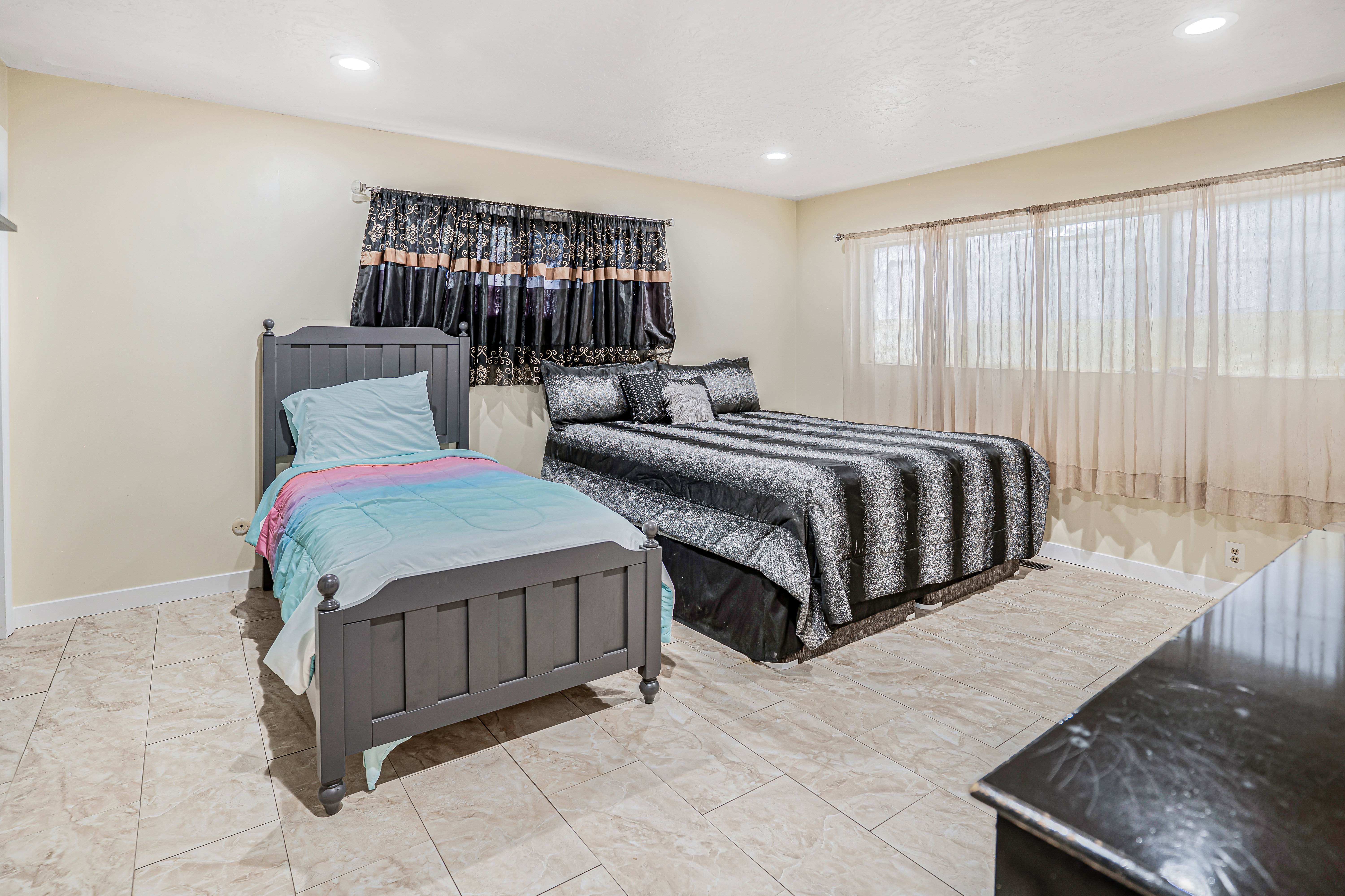 Spacious room featuring neutral wall tones, recessed lighting, and tile flooring