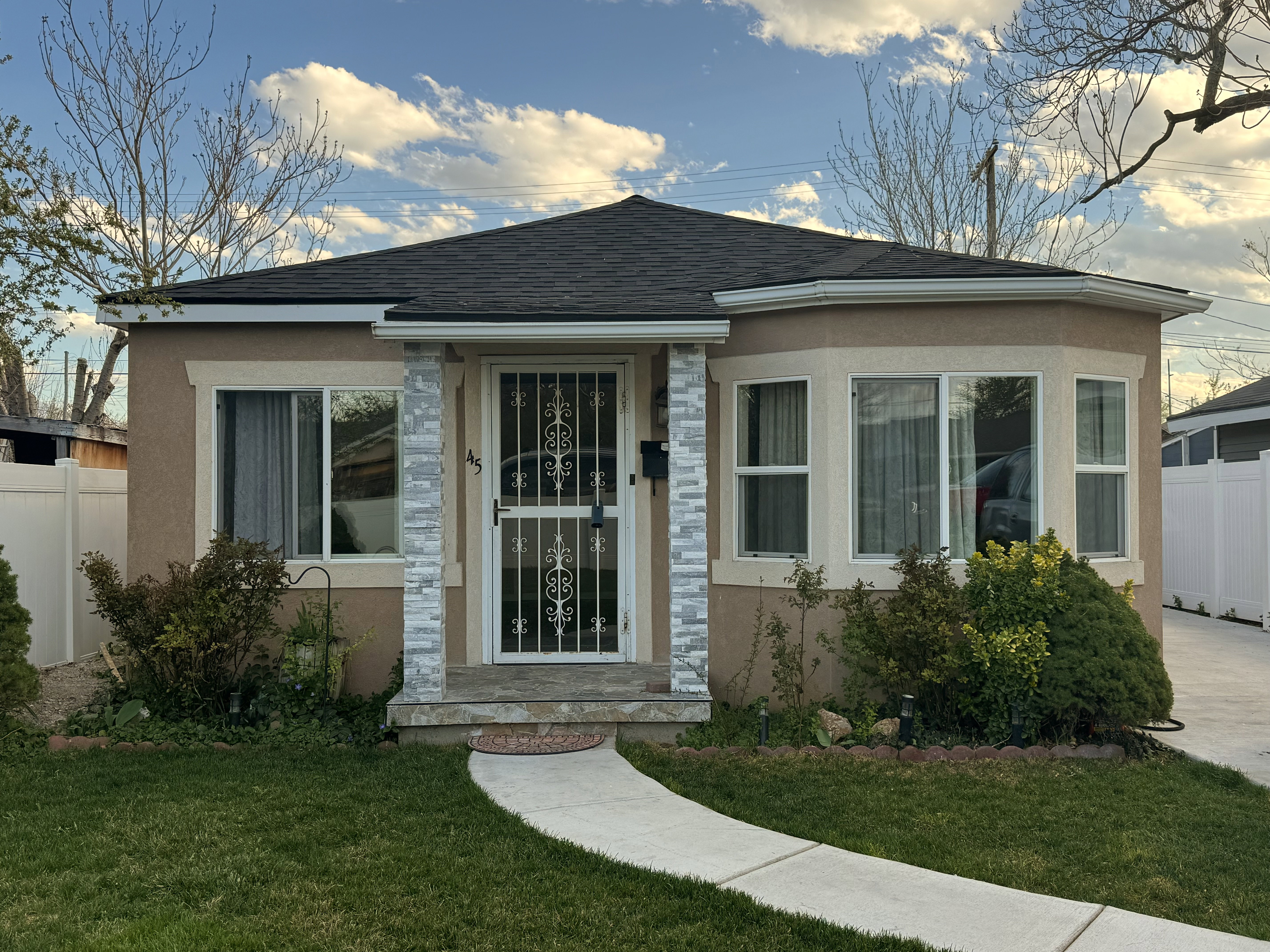 Contemporary stucco exterior with a dark shingle roof