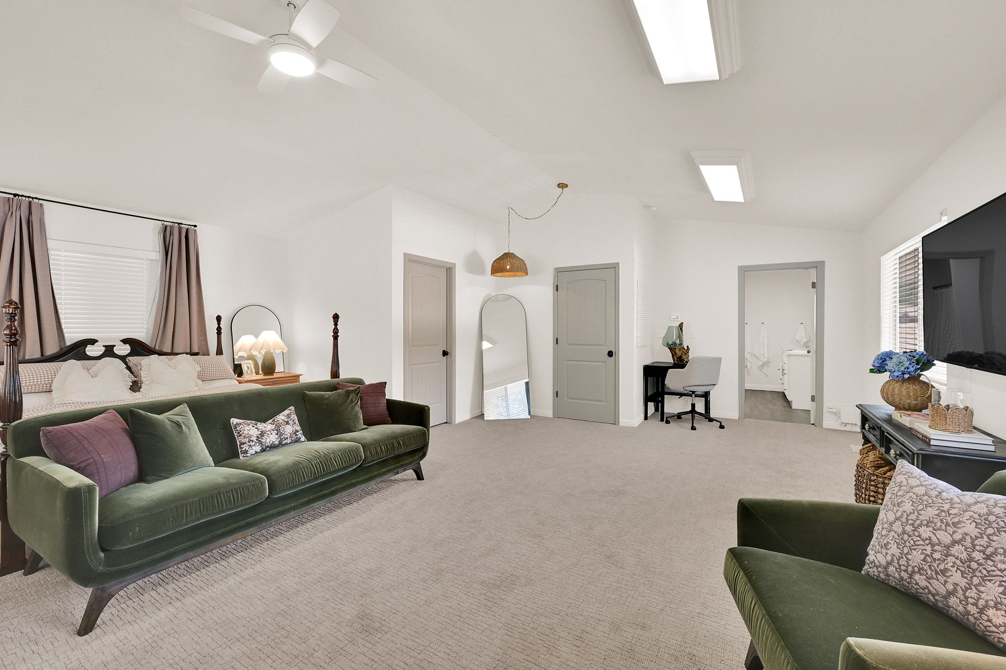 Spacious owners suite featuring vaulted ceilings, recessed lighting, and multiple paneled doors