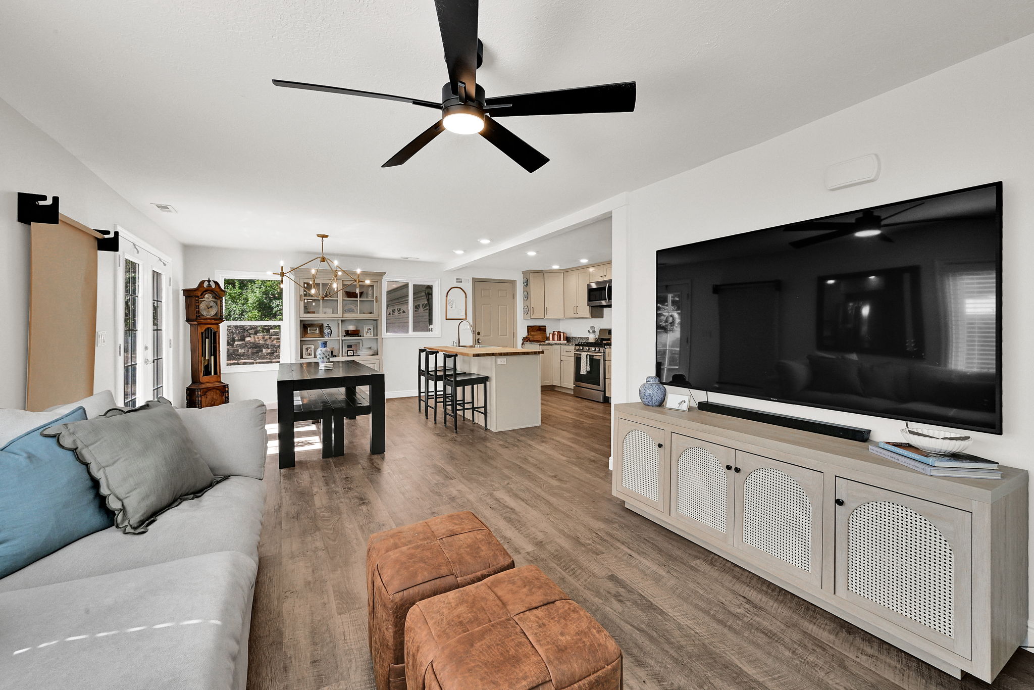 Open-concept living area featuring wood-finish flooring and a contemporary ceiling fan with integrated lighting