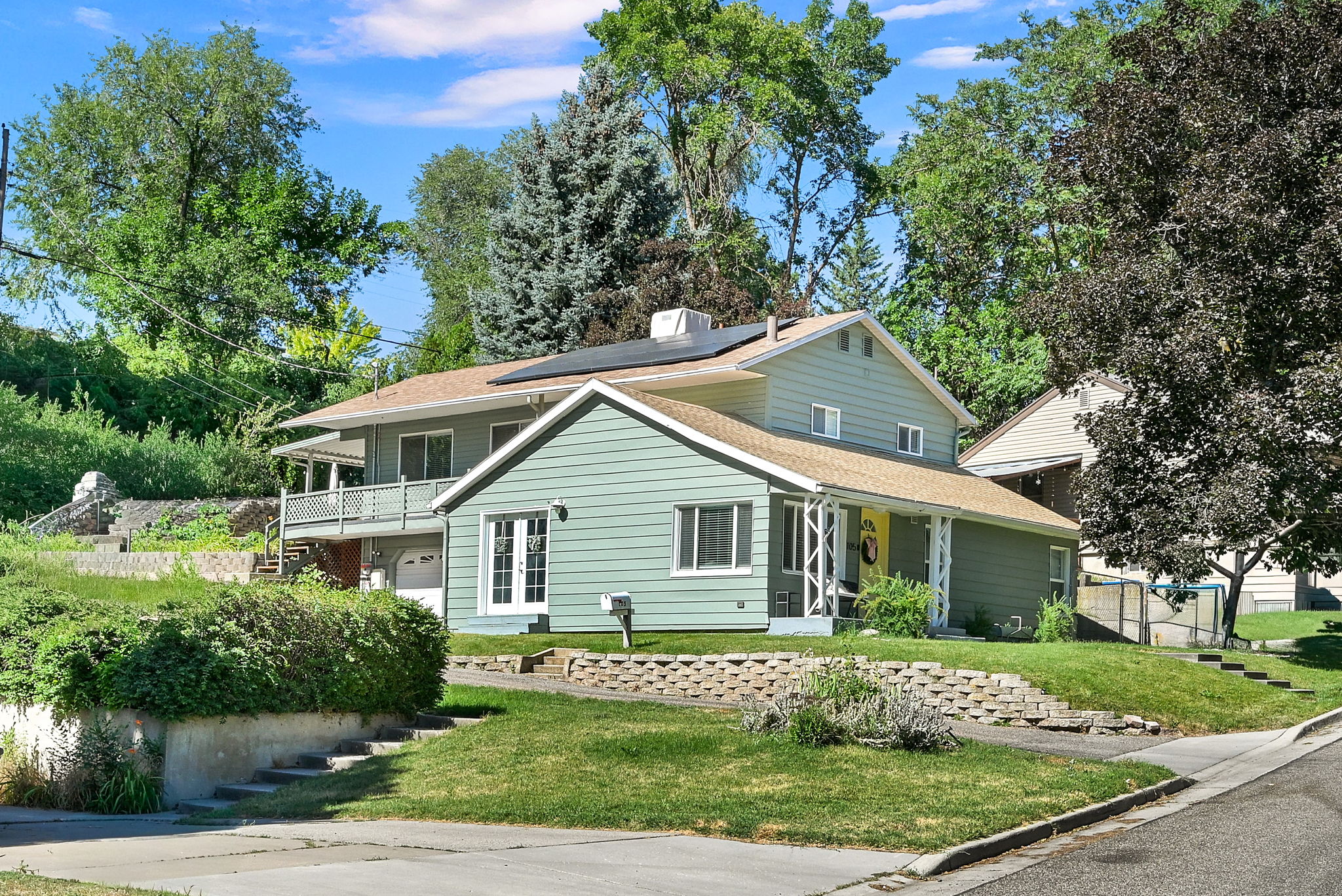 Two-story property featuring light green siding and a covered front porch