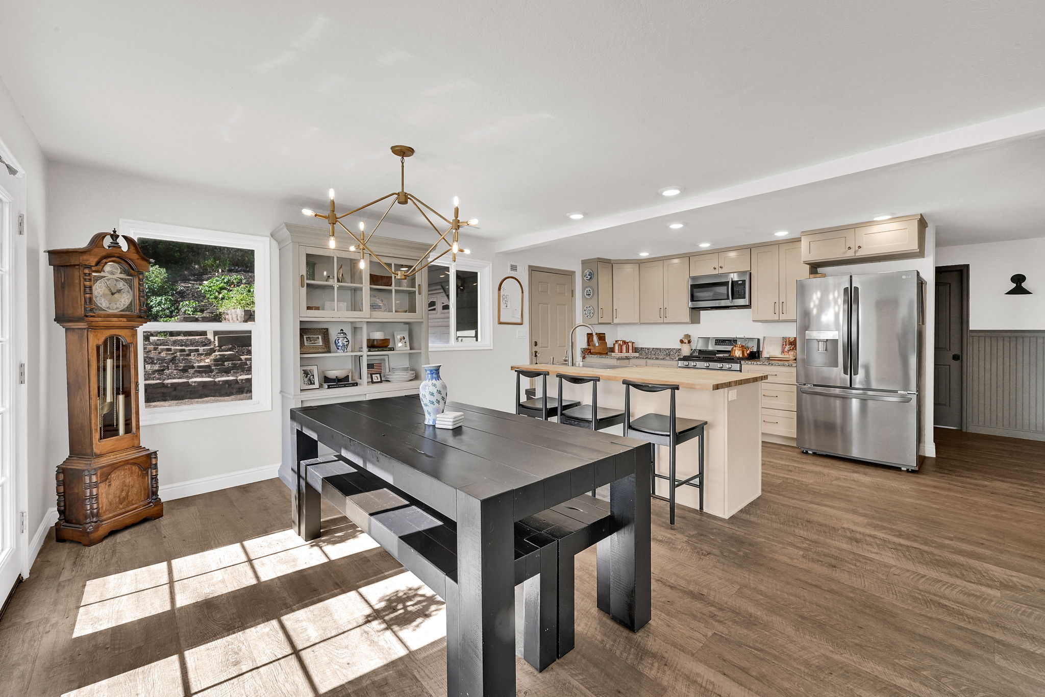 Open-concept living area with wood-finish flooring, a contemporary chandelier, and recessed lighting