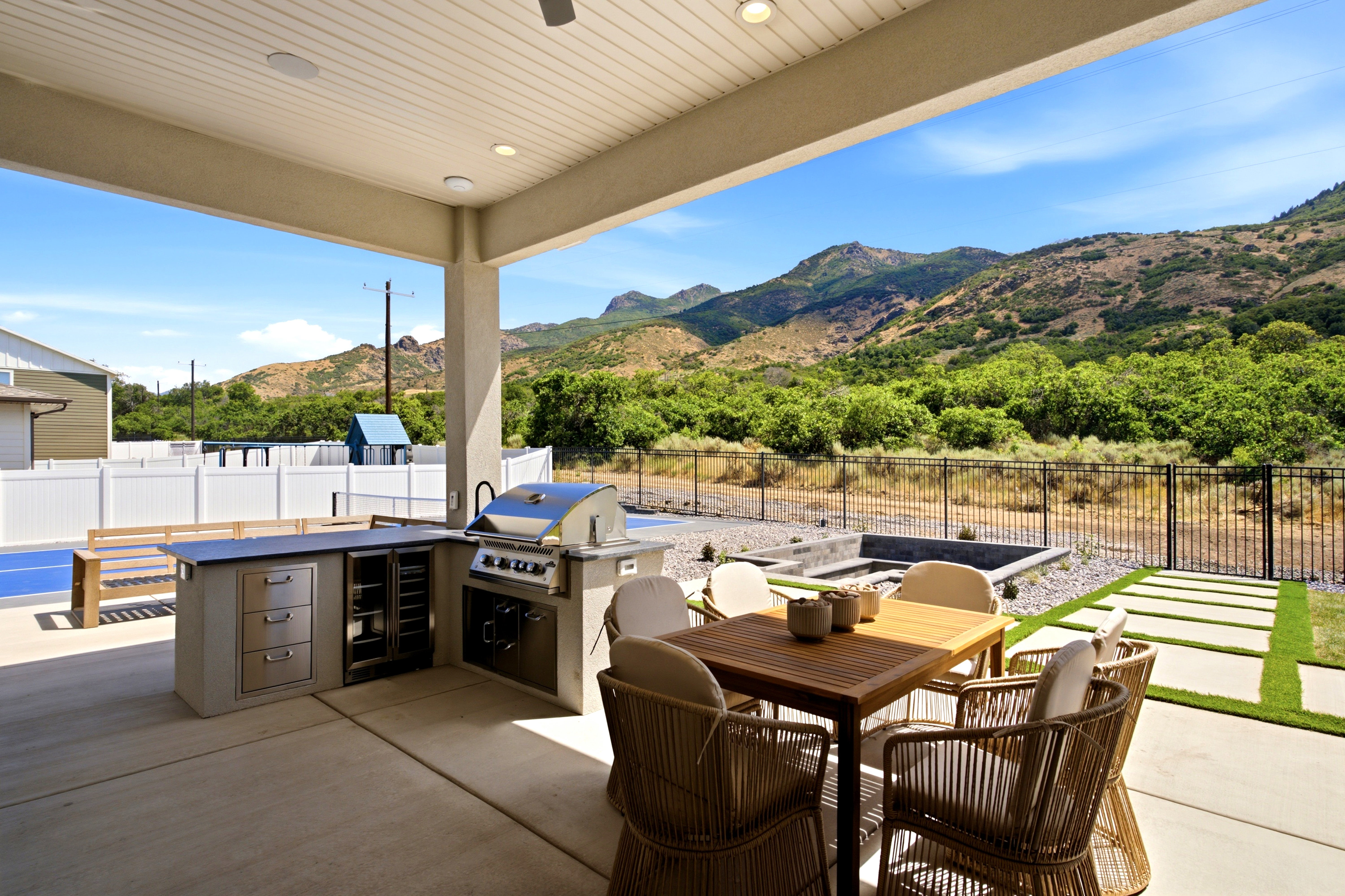 Covered patio featuring an outdoor kitchen with built-in grill and beverage cooler