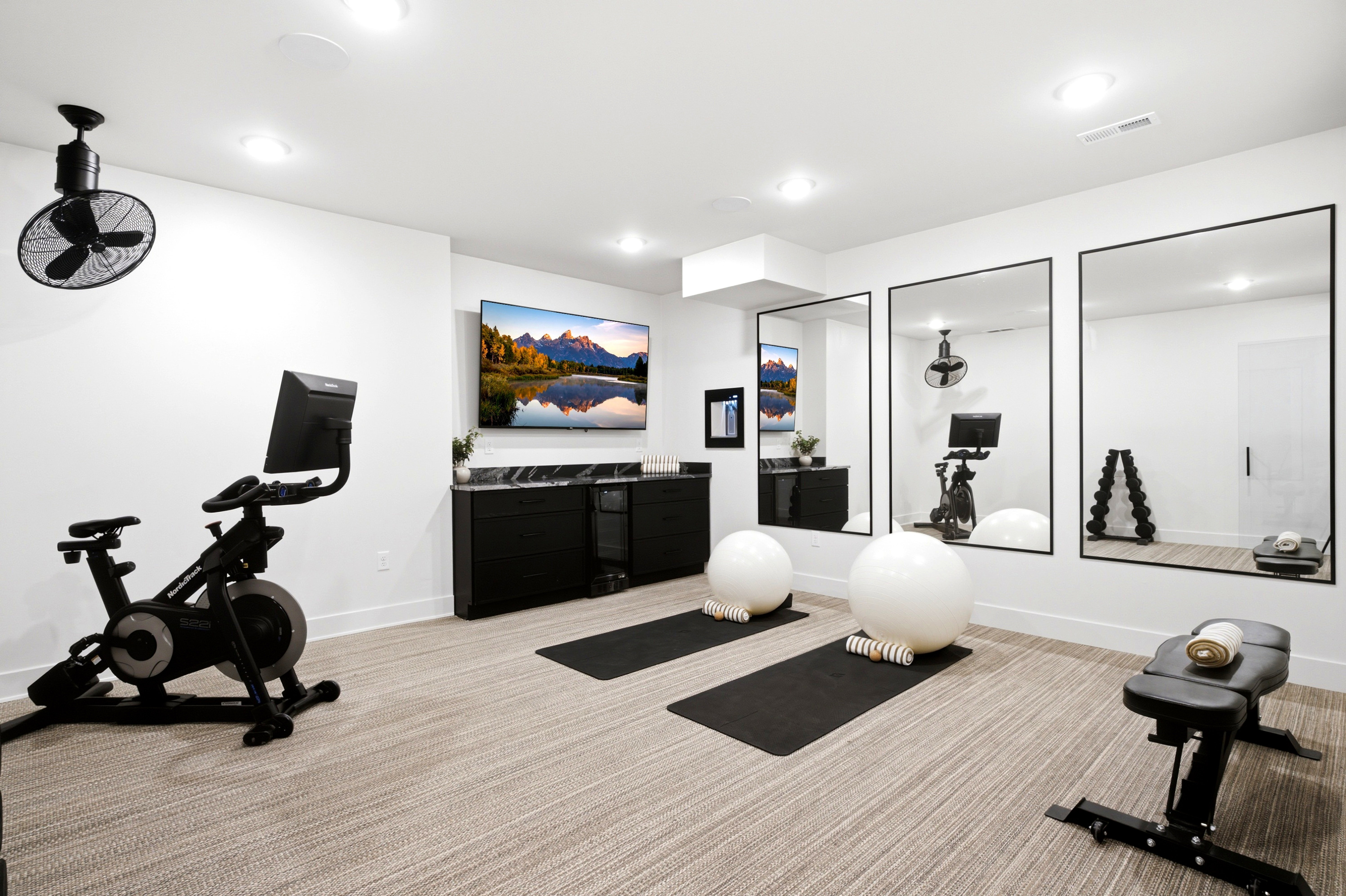 Dedicated fitness space featuring textured carpet flooring, recessed lighting, and wall-mounted mirrors
