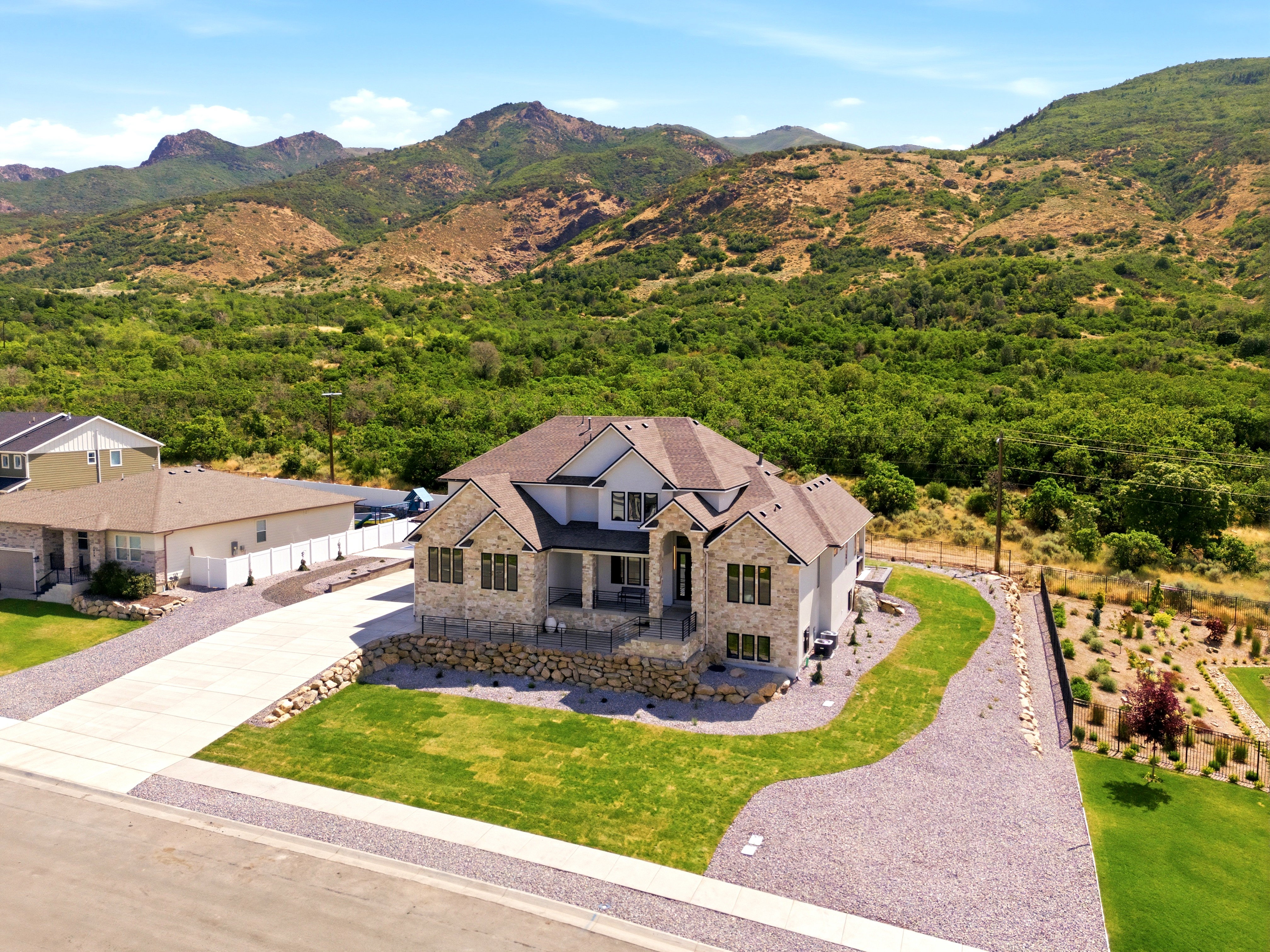 Stone and siding exterior residence with an arched entry and covered porch
