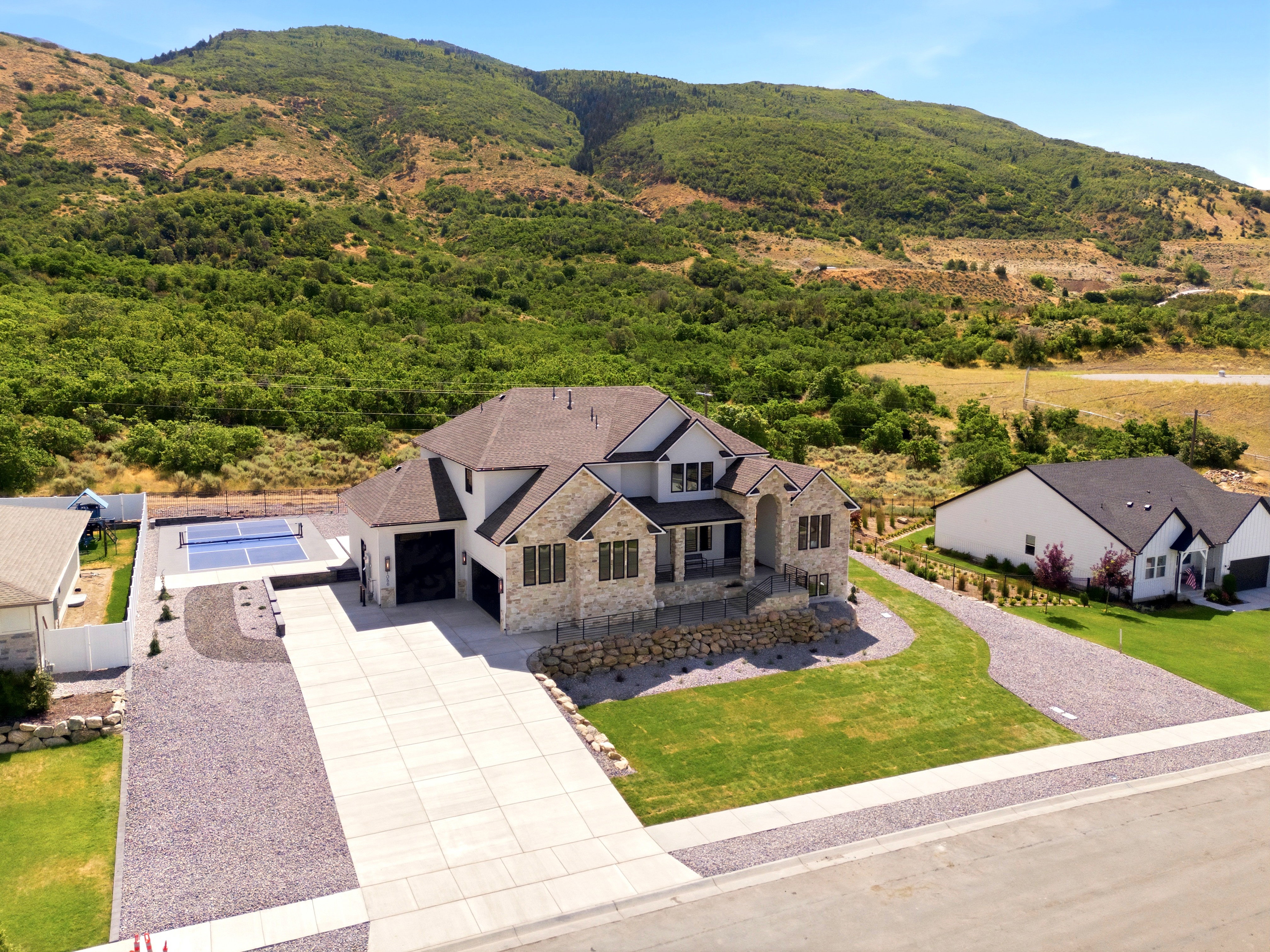 Modern residence featuring a stone and siding exterior with dark trim accents