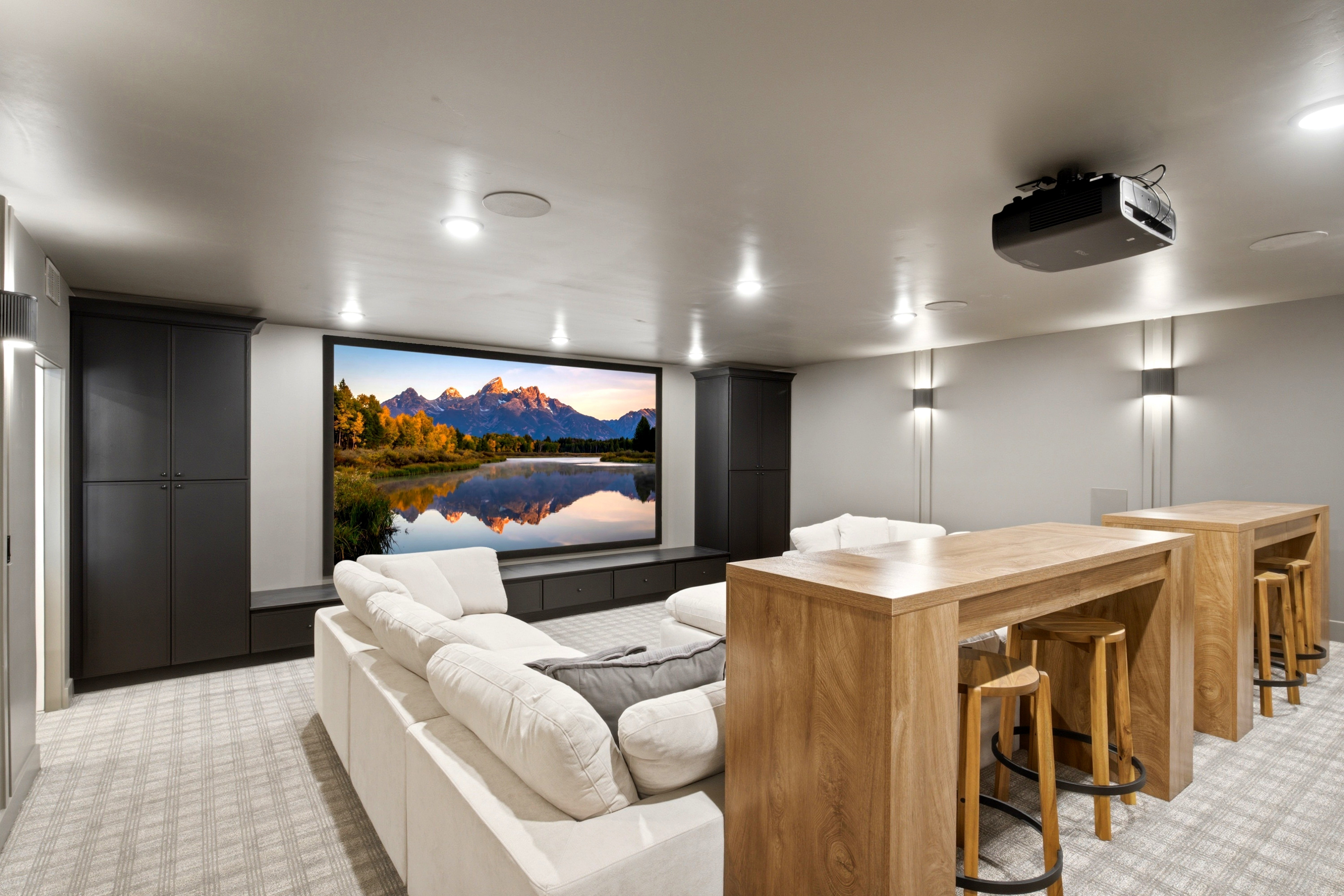 Dedicated media room featuring a large projection screen, mounted projector, and recessed lighting