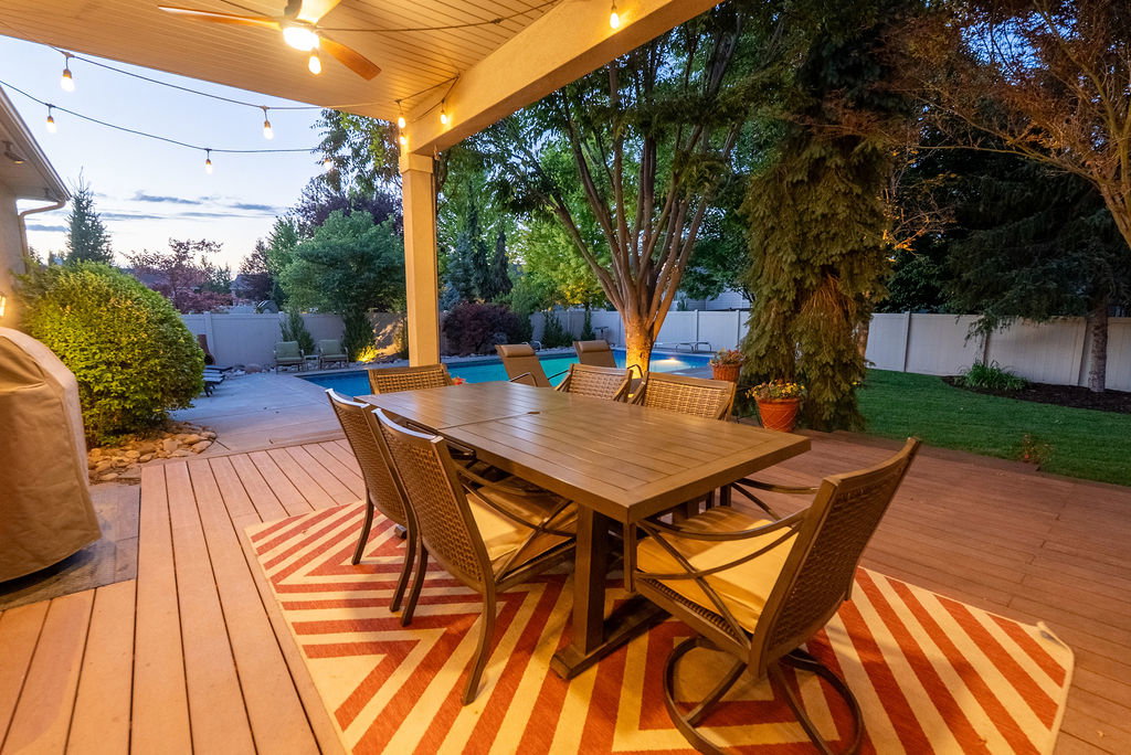 Covered patio featuring a ceiling fan, string lights, and wood-finish decking