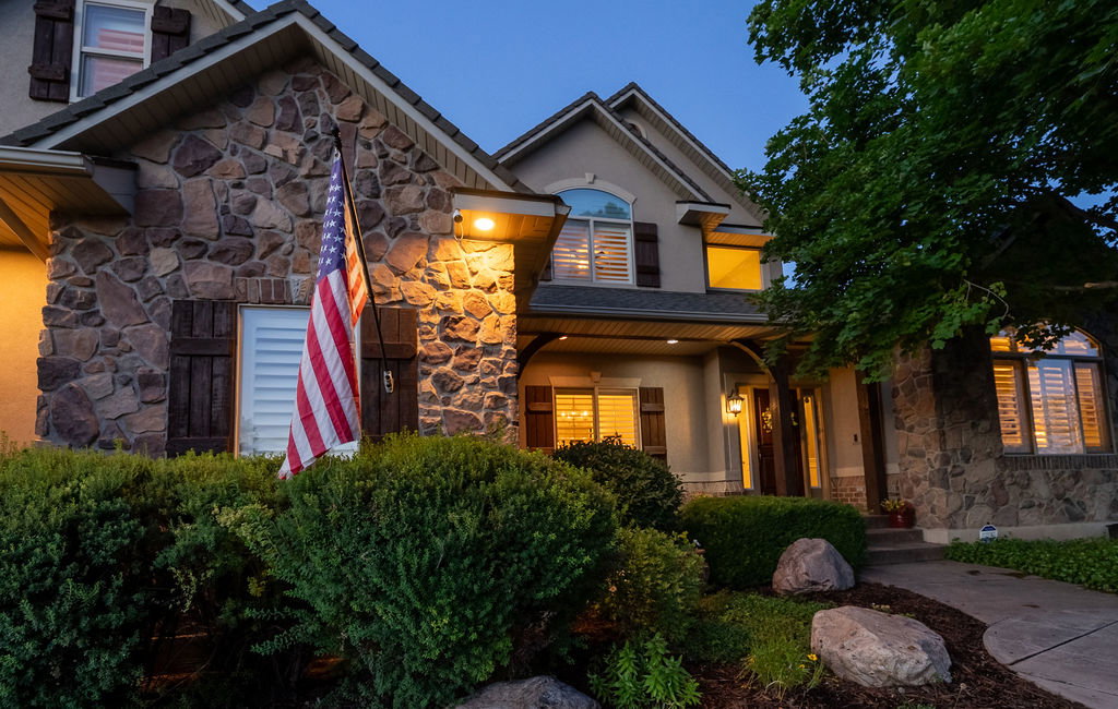 Stone and stucco facade with dark wood shutters and arched windows