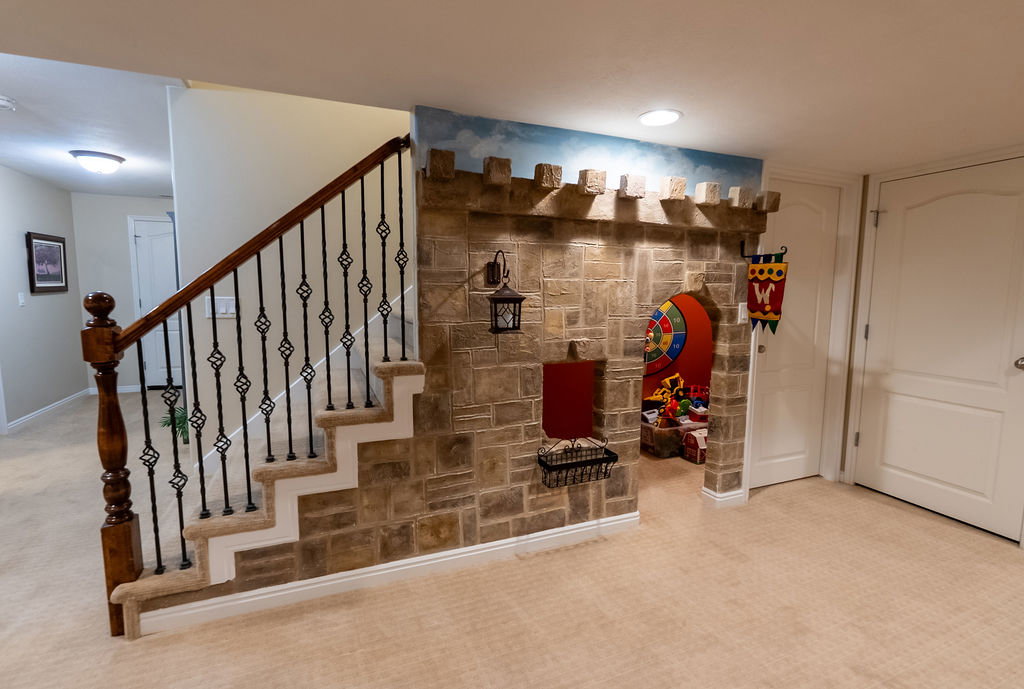 Staircase featuring an ornate wrought iron railing with a wood newel post and handrail