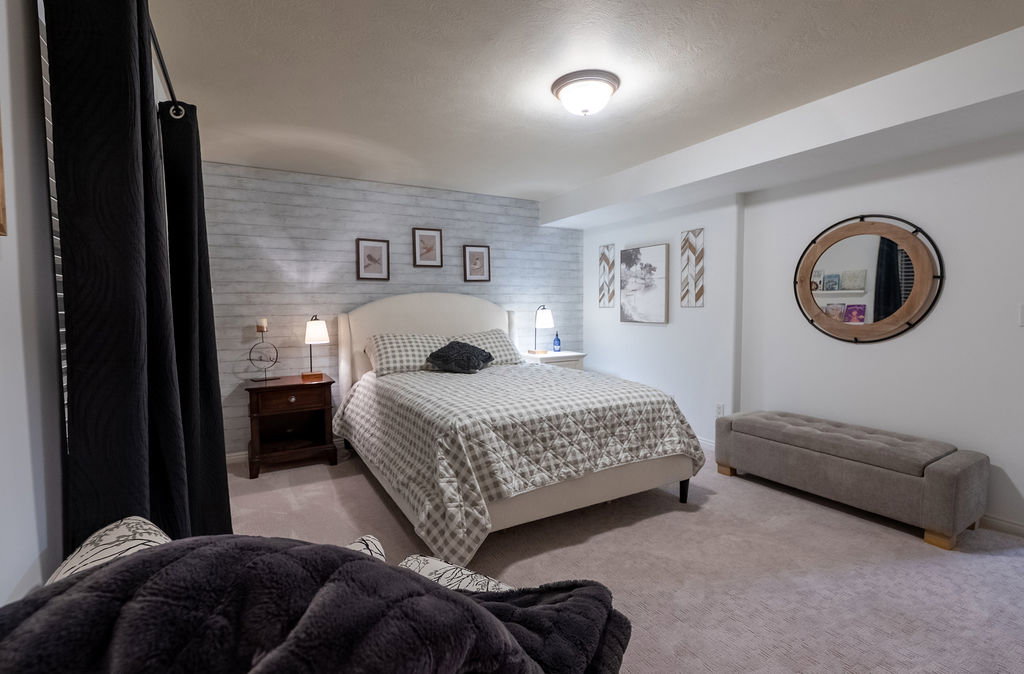 Carpeted interior space featuring a textured accent wall and a white wall finish