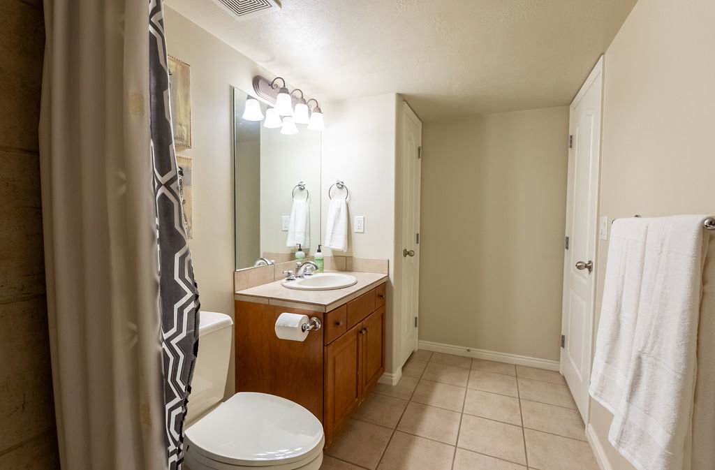 Bathroom vanity featuring a light-colored countertop, an undermount sink, and a mirrored backsplash