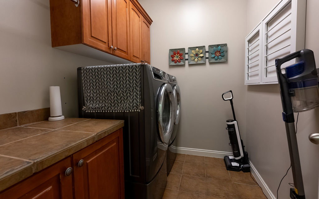 Dedicated laundry area featuring cabinetry, tile flooring, and a tile countertop