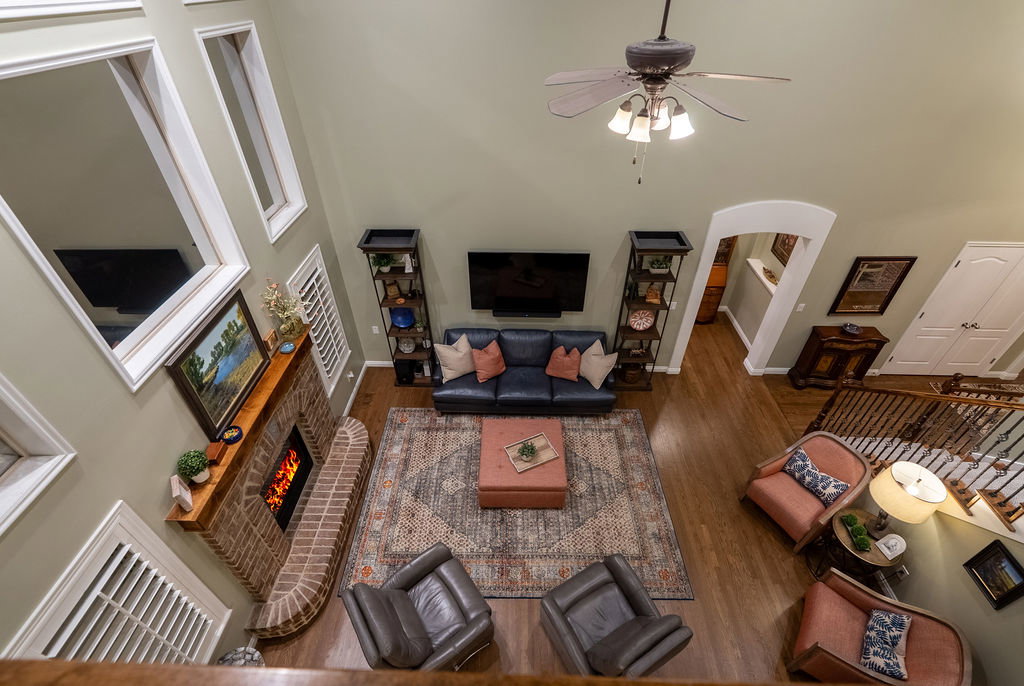 Living area featuring wood-finish flooring and a brick fireplace with a wood mantel
