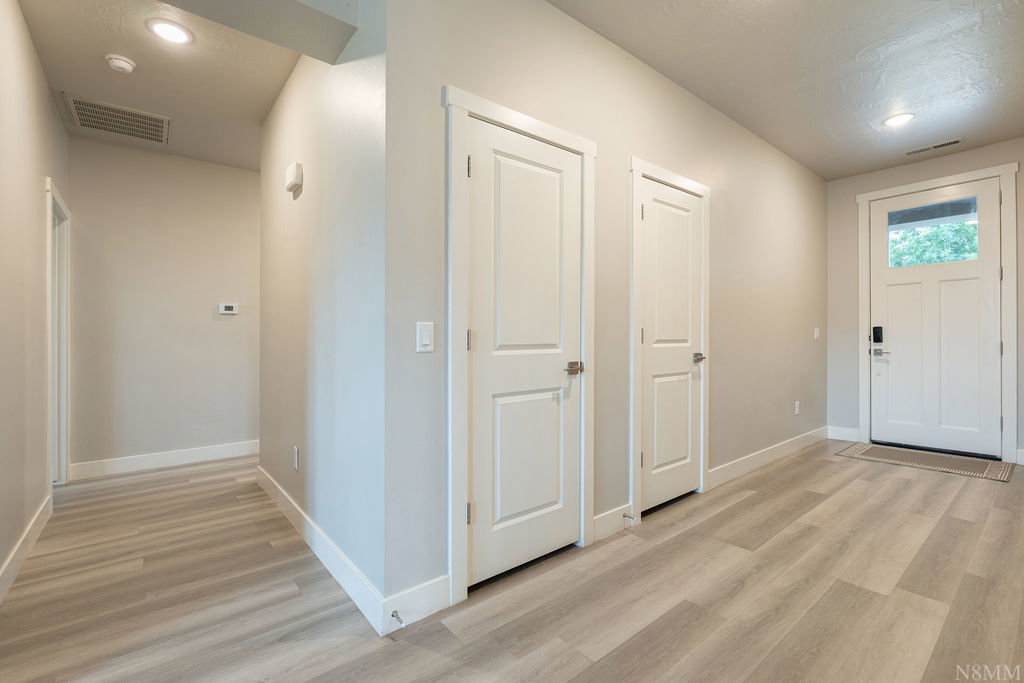 Entryway featuring wood-finish flooring, two panel doors, recessed lighting, and a front door with an integrated window