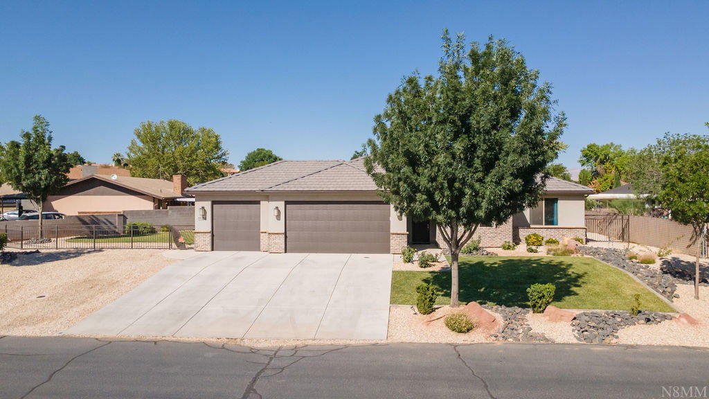 Ranch-style residence featuring a two-car garage with individual doors, a concrete driveway, and a tiled roof