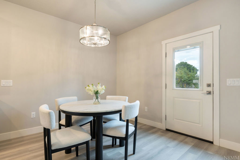 Light wood-finish flooring provides a neutral foundation for this room, featuring a white door with a clear glass insert