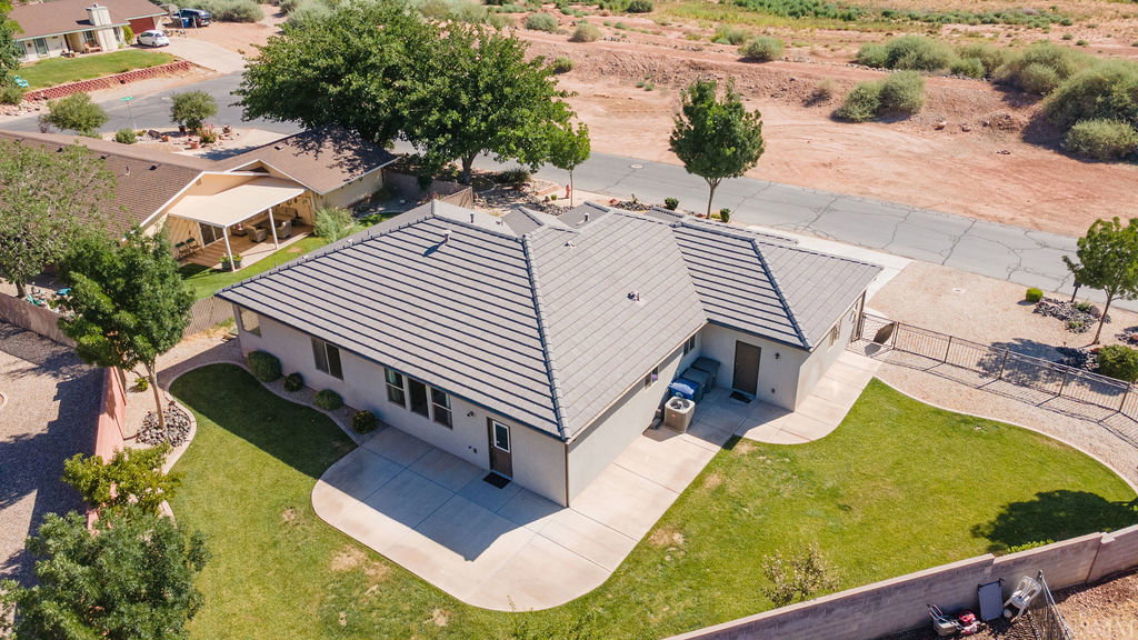 Single-story residence featuring a tile roof, light-toned exterior siding, and a concrete patio