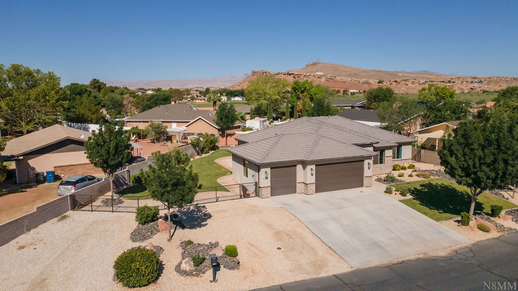 Single-story residence featuring a tile roof, dual garage doors, and stone facade accents