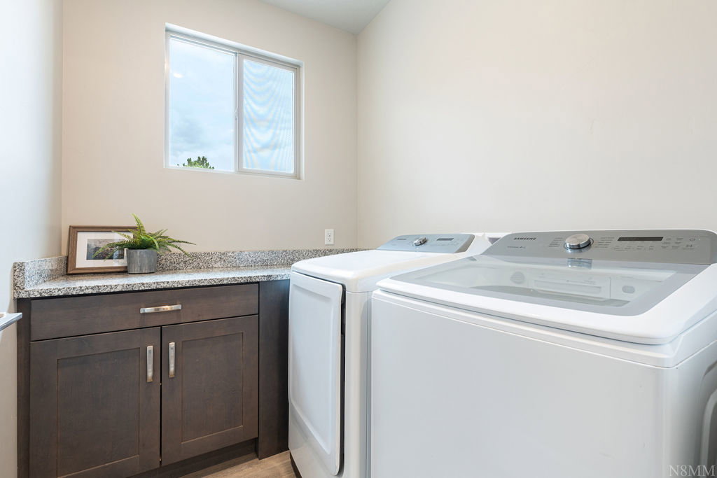 Laundry area featuring a window, dark wood-finish cabinetry, and a light-toned countertop