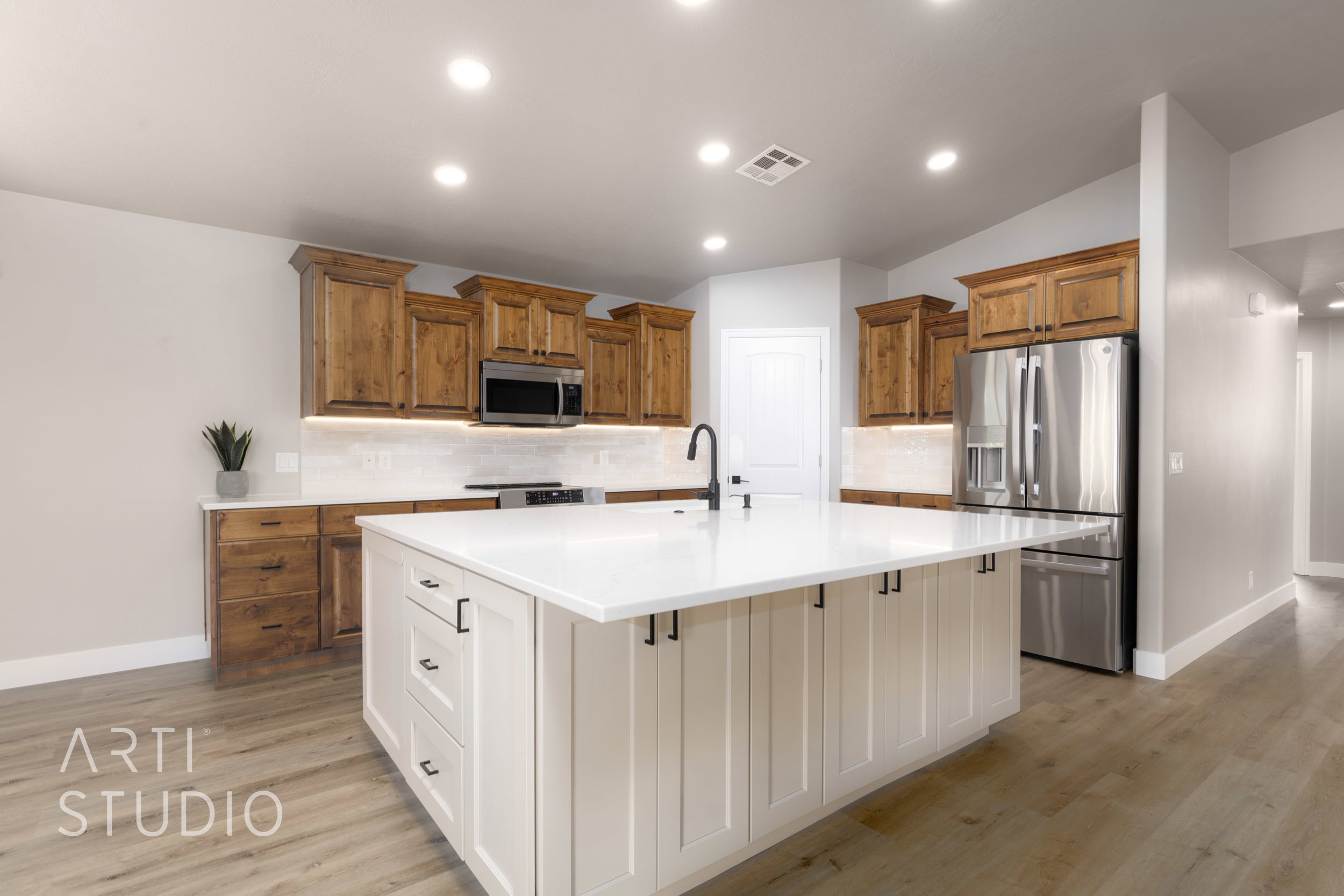 Kitchen featuring a large central island with white cabinetry and a light-toned countertop