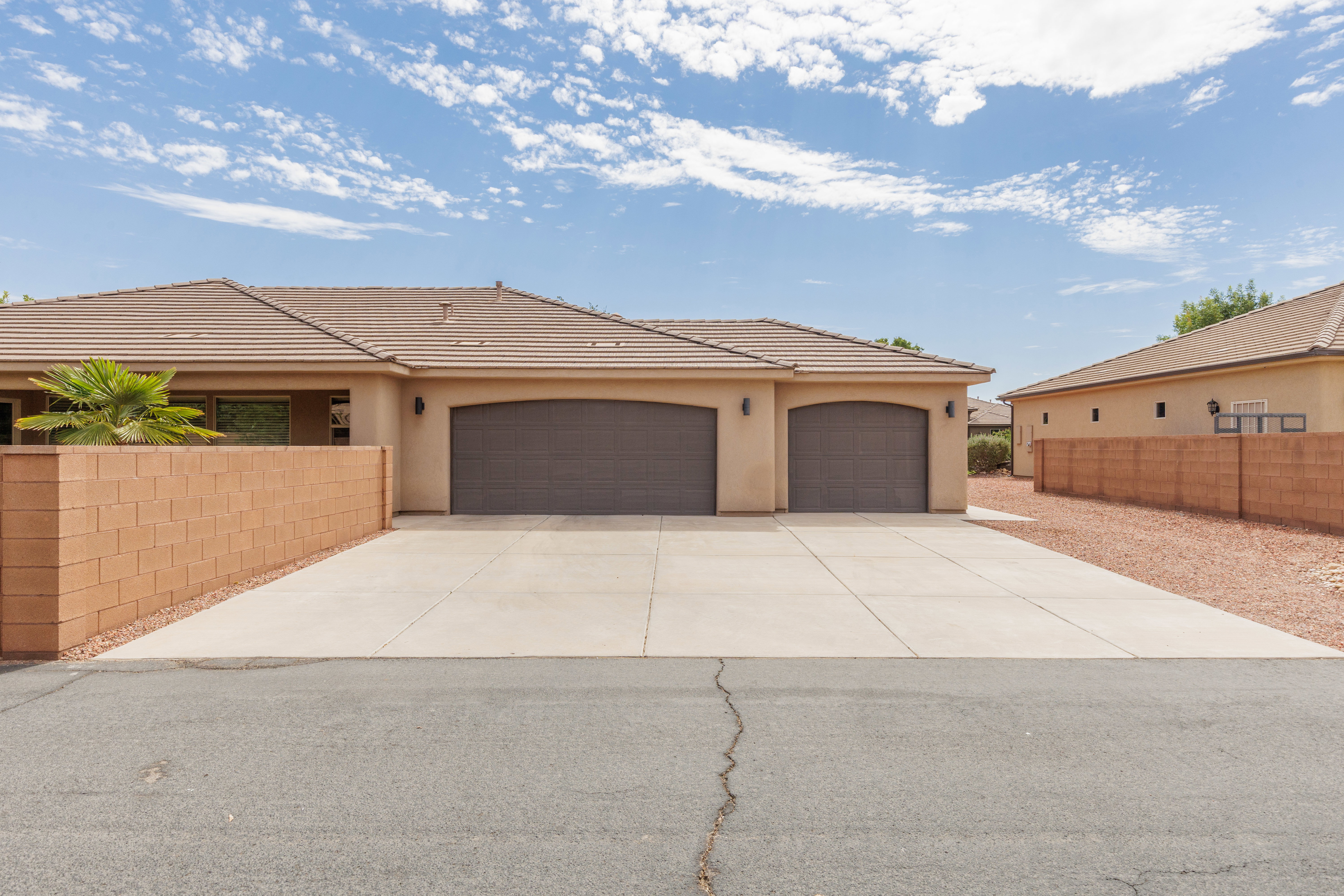 Single-story residence featuring a tan stucco exterior and a 3-car concrete driveway and RV parking