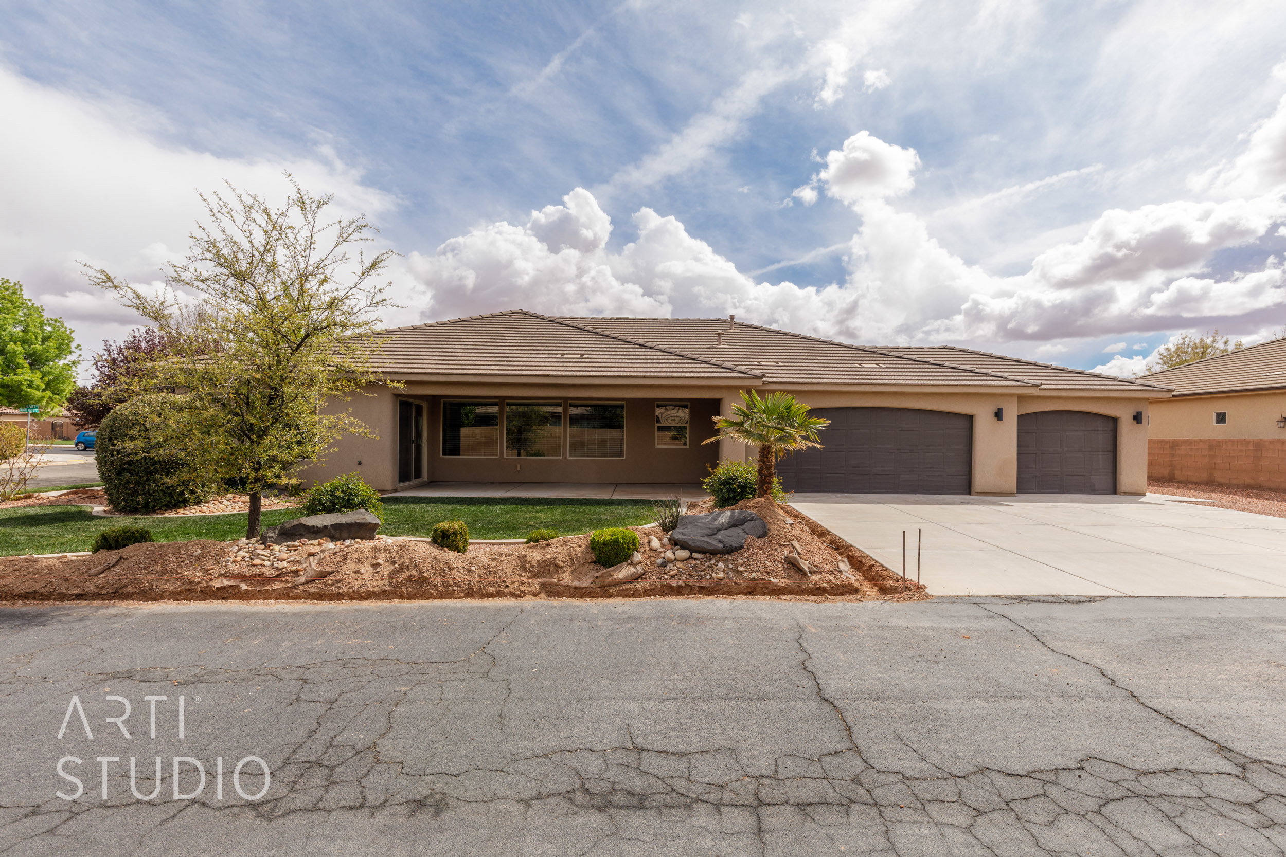 Single-story residence featuring a neutral stucco exterior and a tiled roof. Backyard has been enclosed with a block wall.